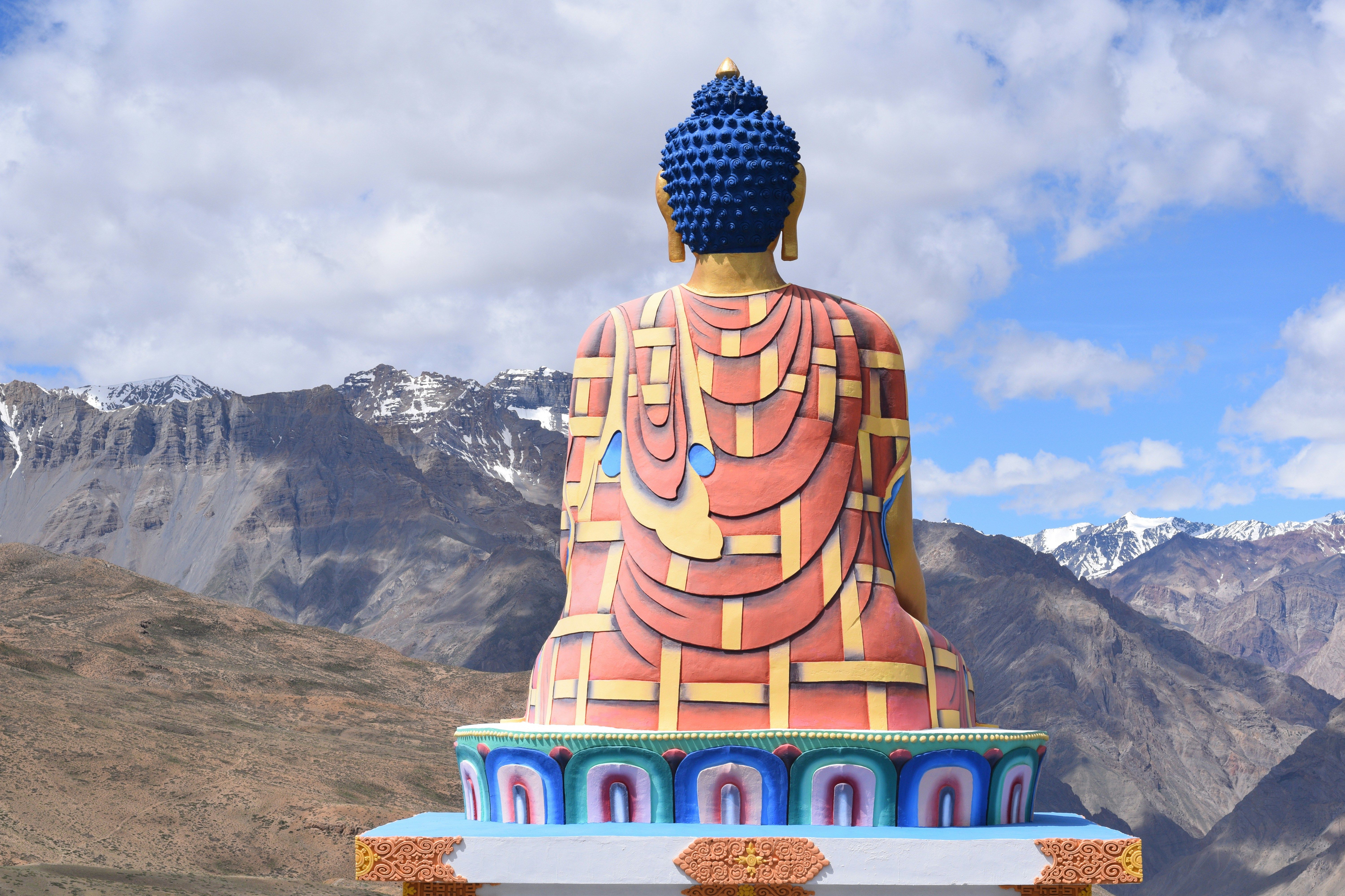 a large statue of gautam buddha sitting on top of a hill in langza village in spiti valley