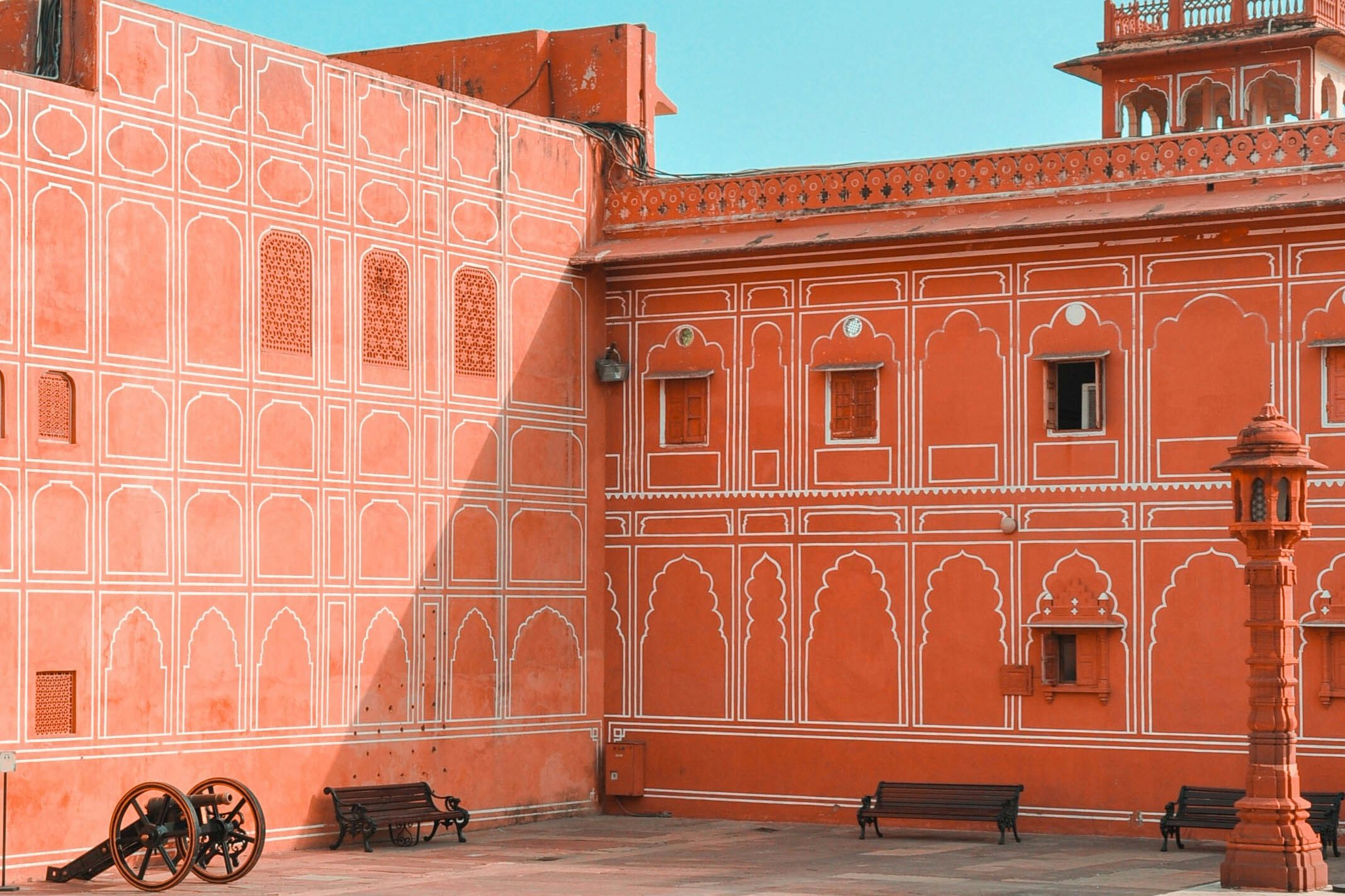 a large orange colored building with lots of windows and a clock tower in jaipur