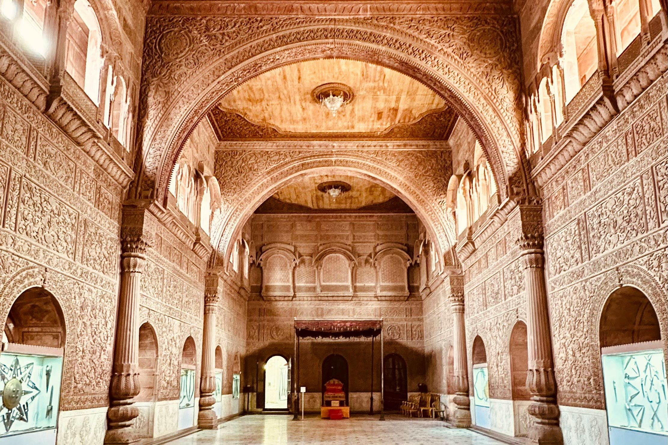 a large hall with a clock on the ceiling at junagarh fort in bikaner