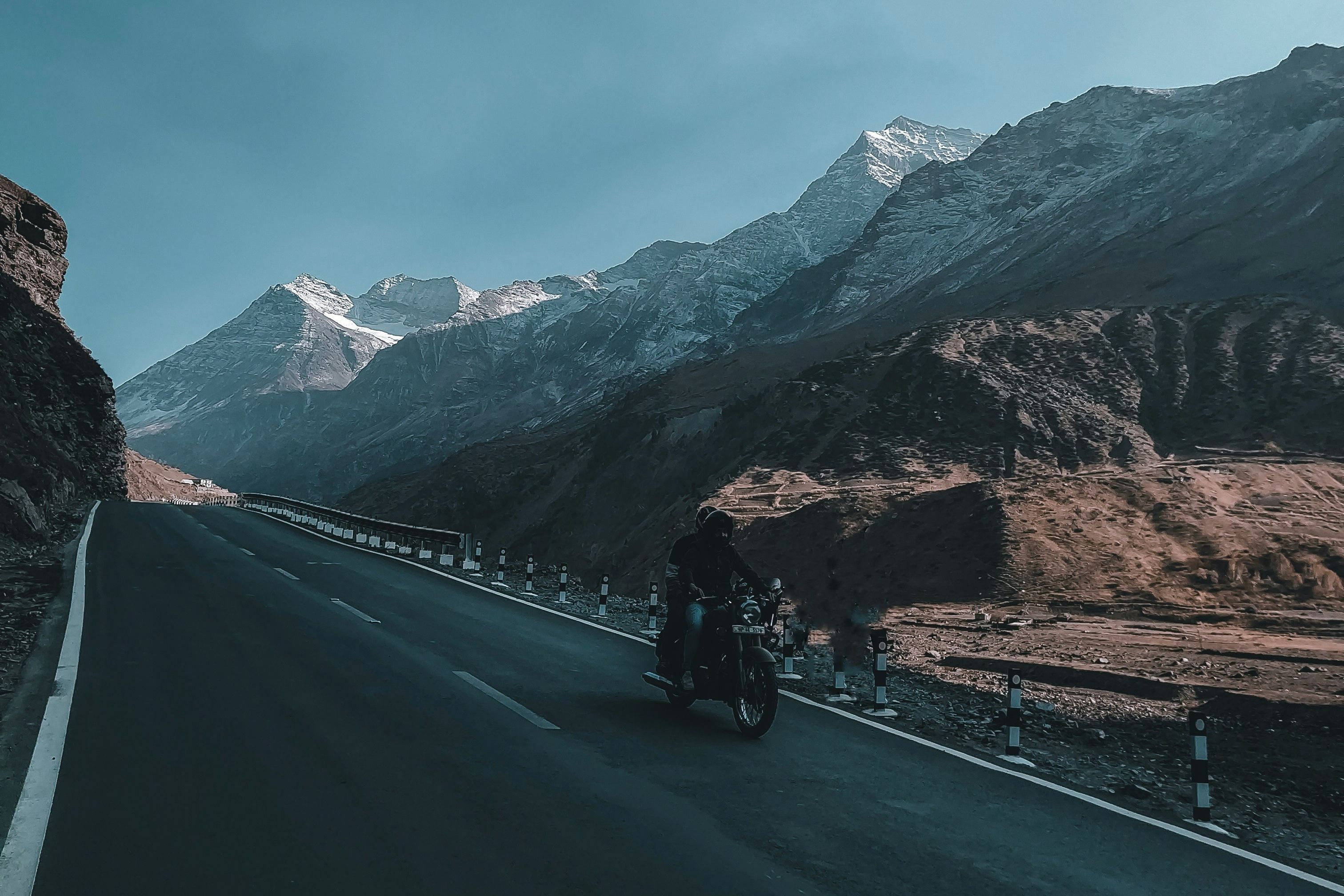 a motorcycle on road near mountain during daytime in sissu