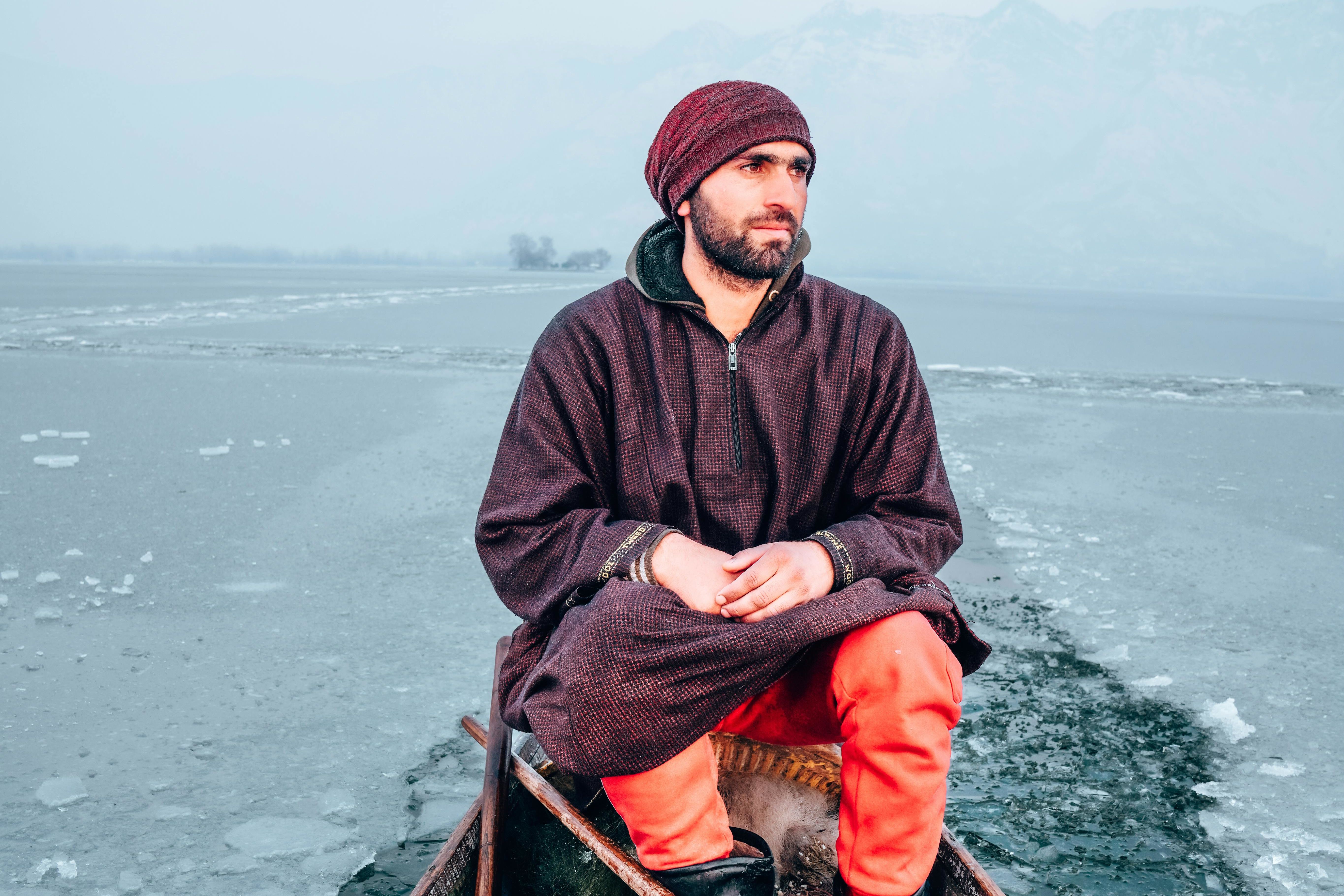 a person sitting on a boat in freezing lake