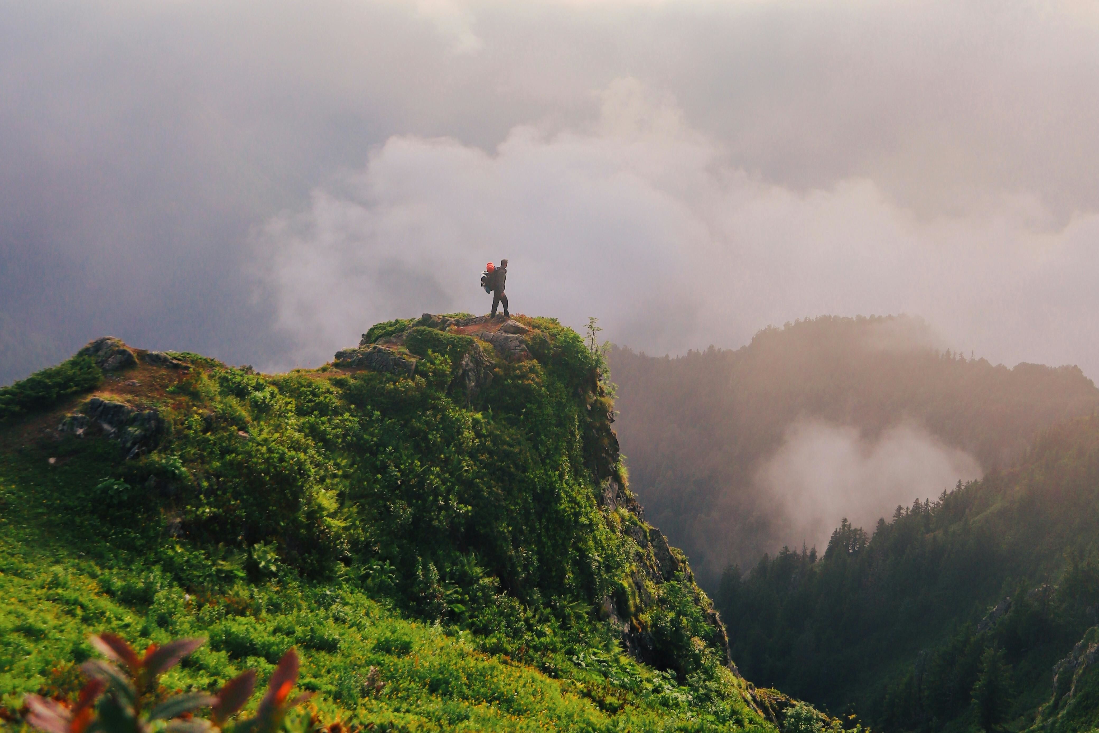 a person standing on a rock over hills