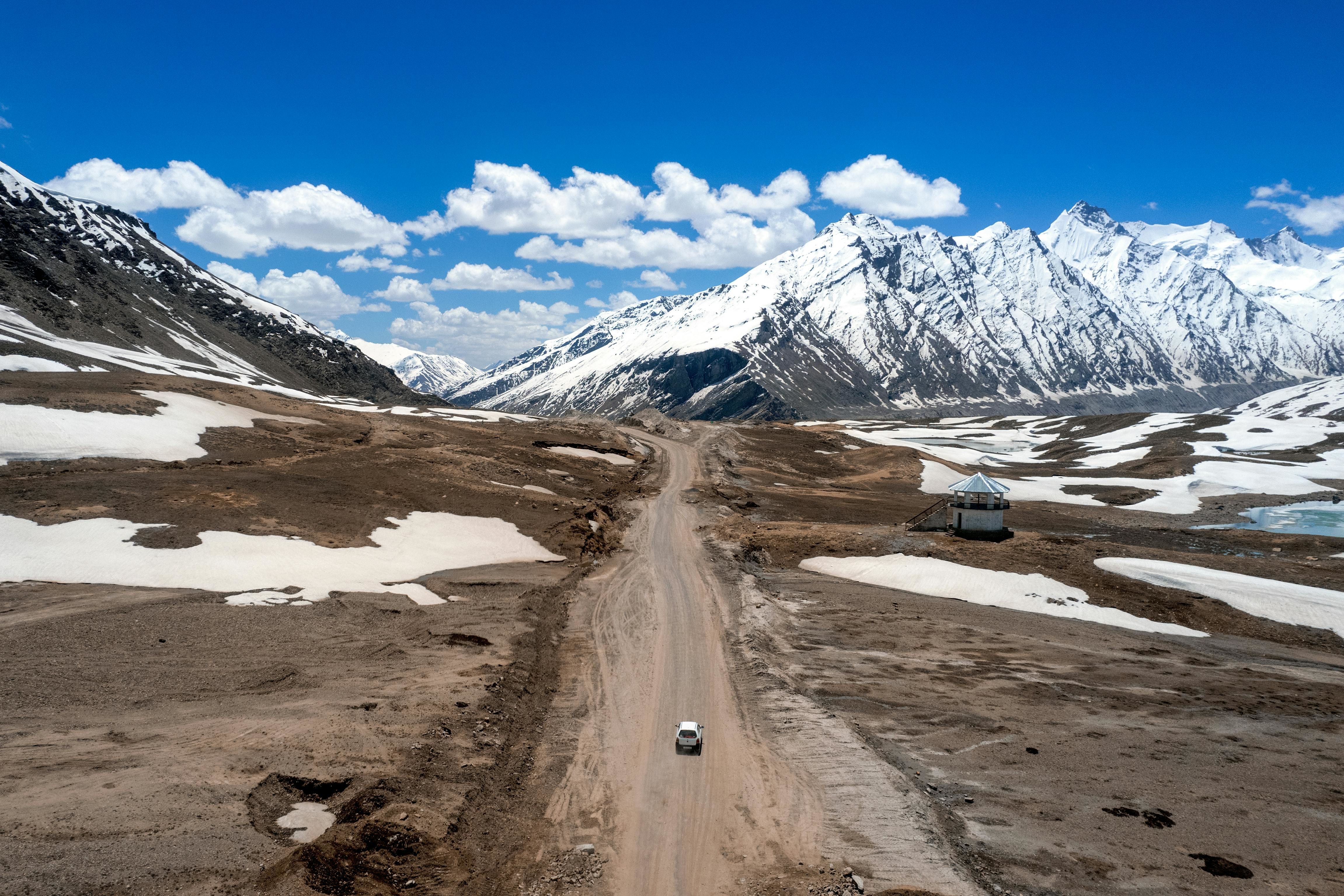a road in the middle of a snowy mountain range in zanskar valley