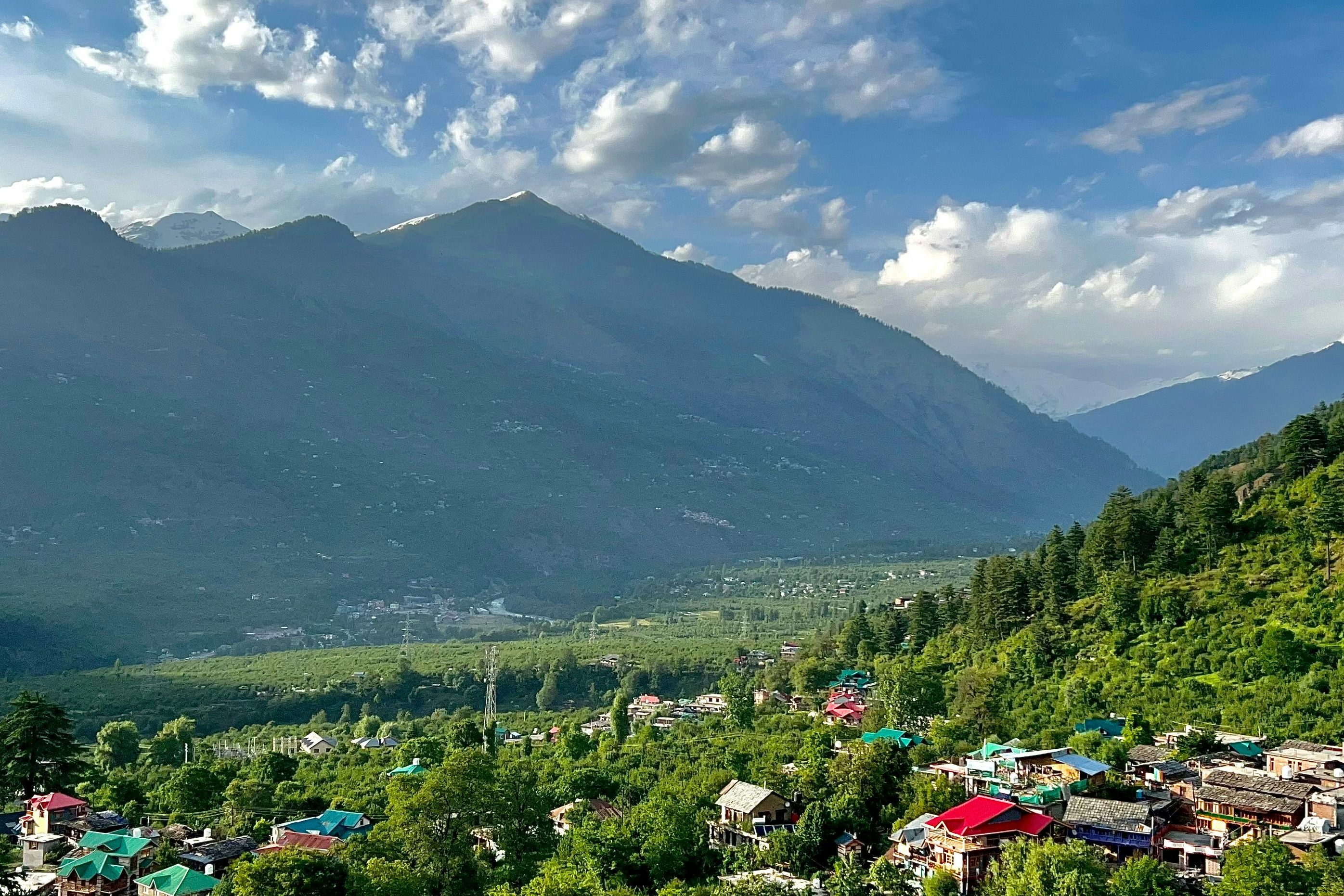 a scenic view of naggar village in the mountains