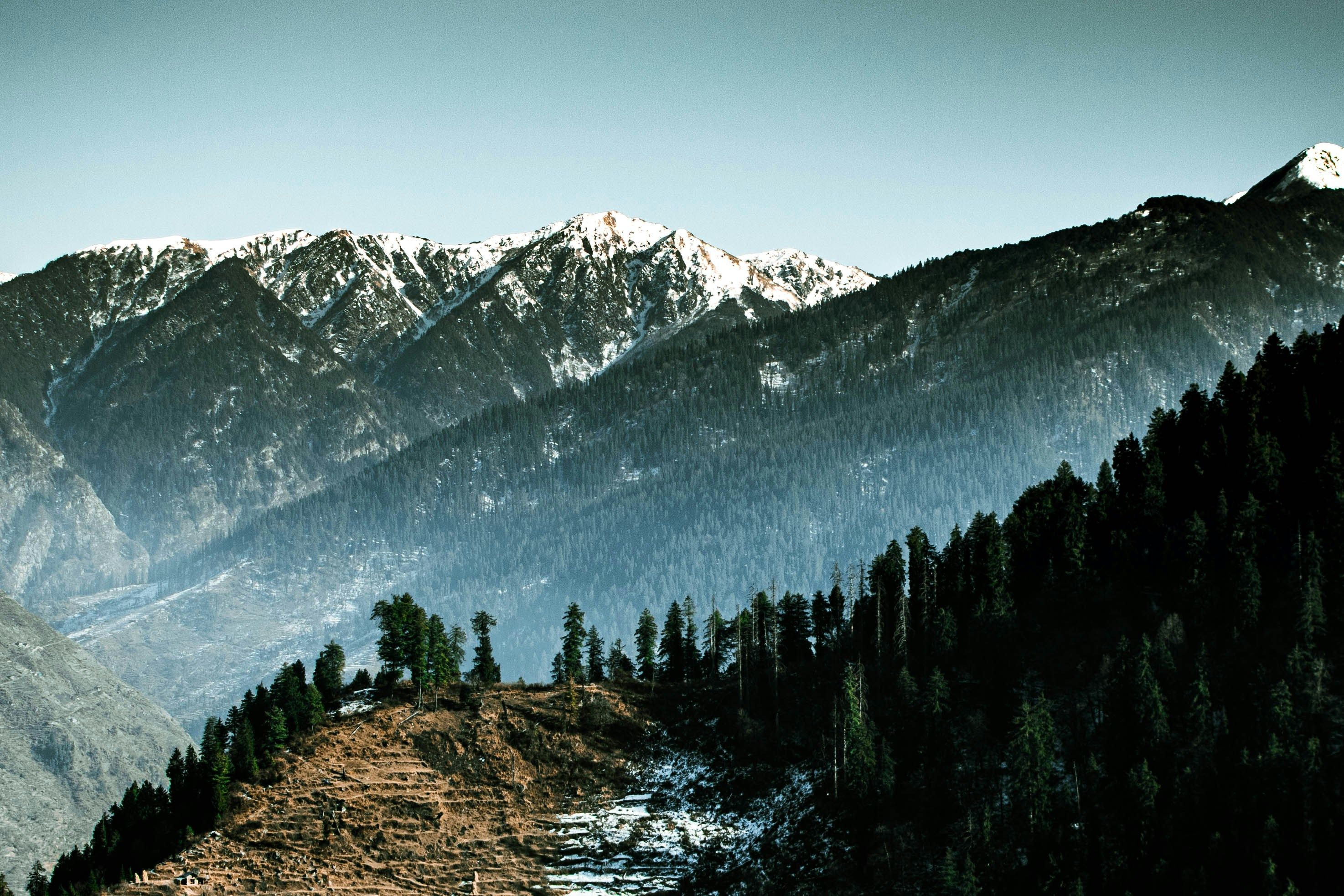 view of a snowy mountain range in tirthan valley