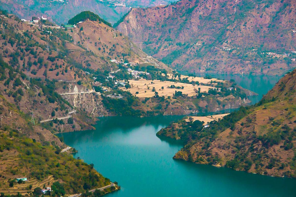 a view of brown mountains surrounding the chamera lake