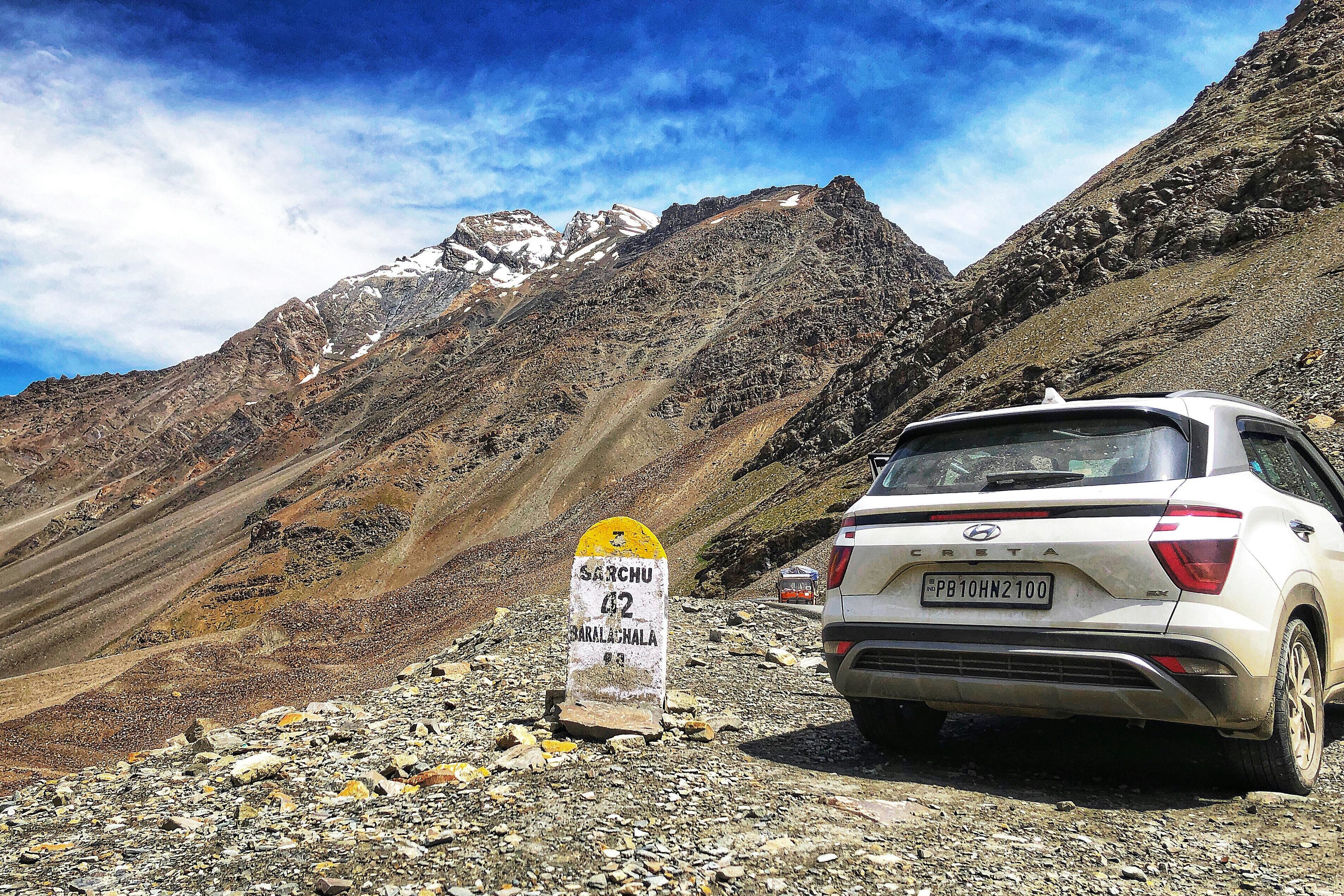 A white car near the mountain at baralacha la pass