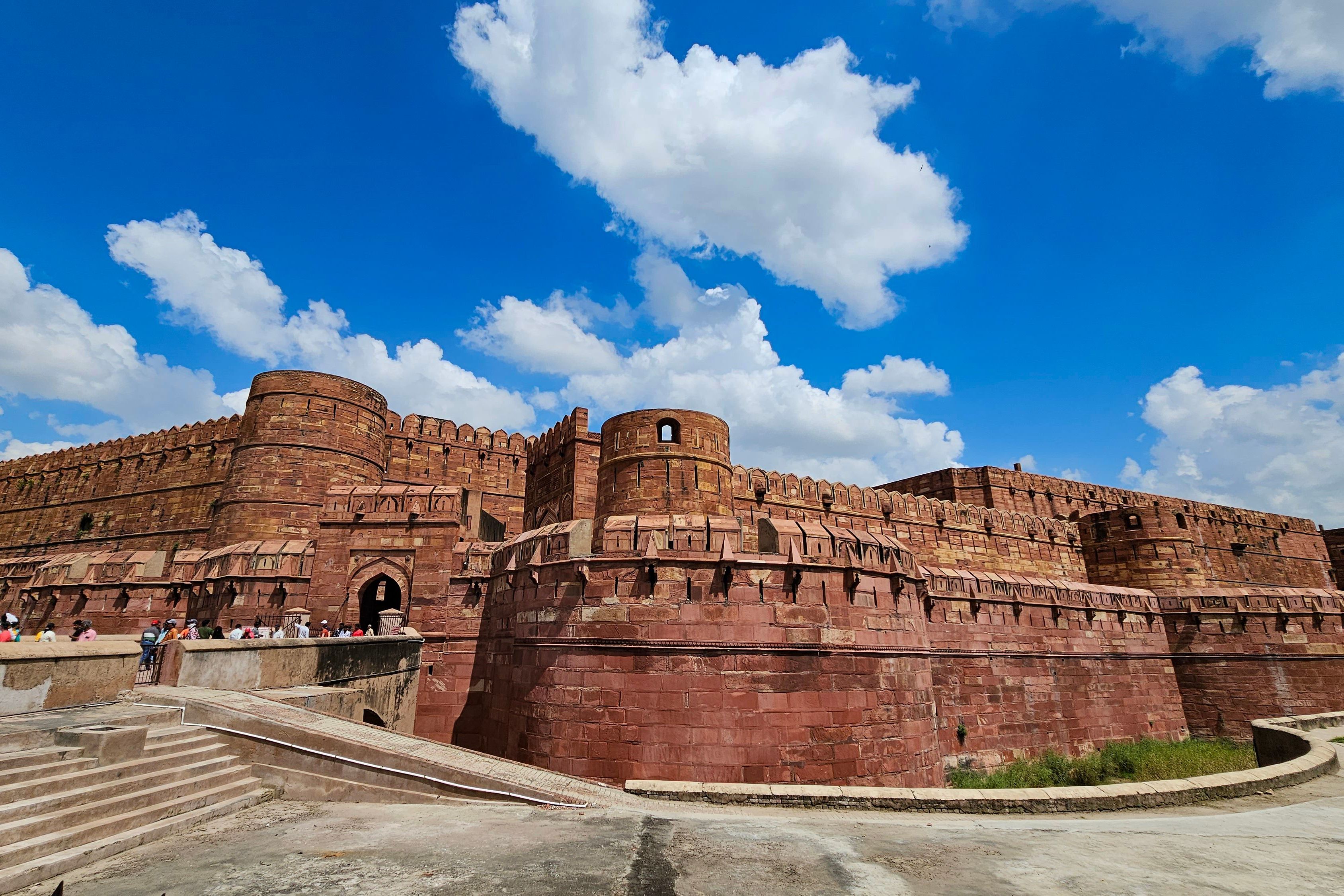 architectural detail of agra fort with tourists enjoying a sunny day under clear blue sky