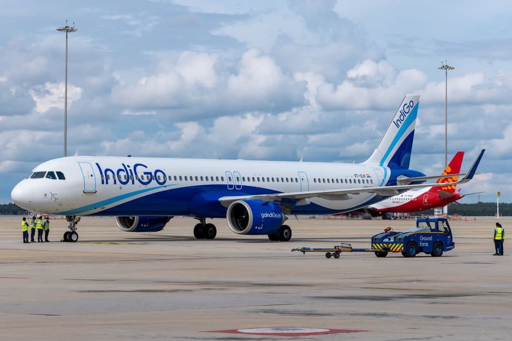 ground staff standing near an indigo aeroplane standing on jaipur international airport runway during daytime