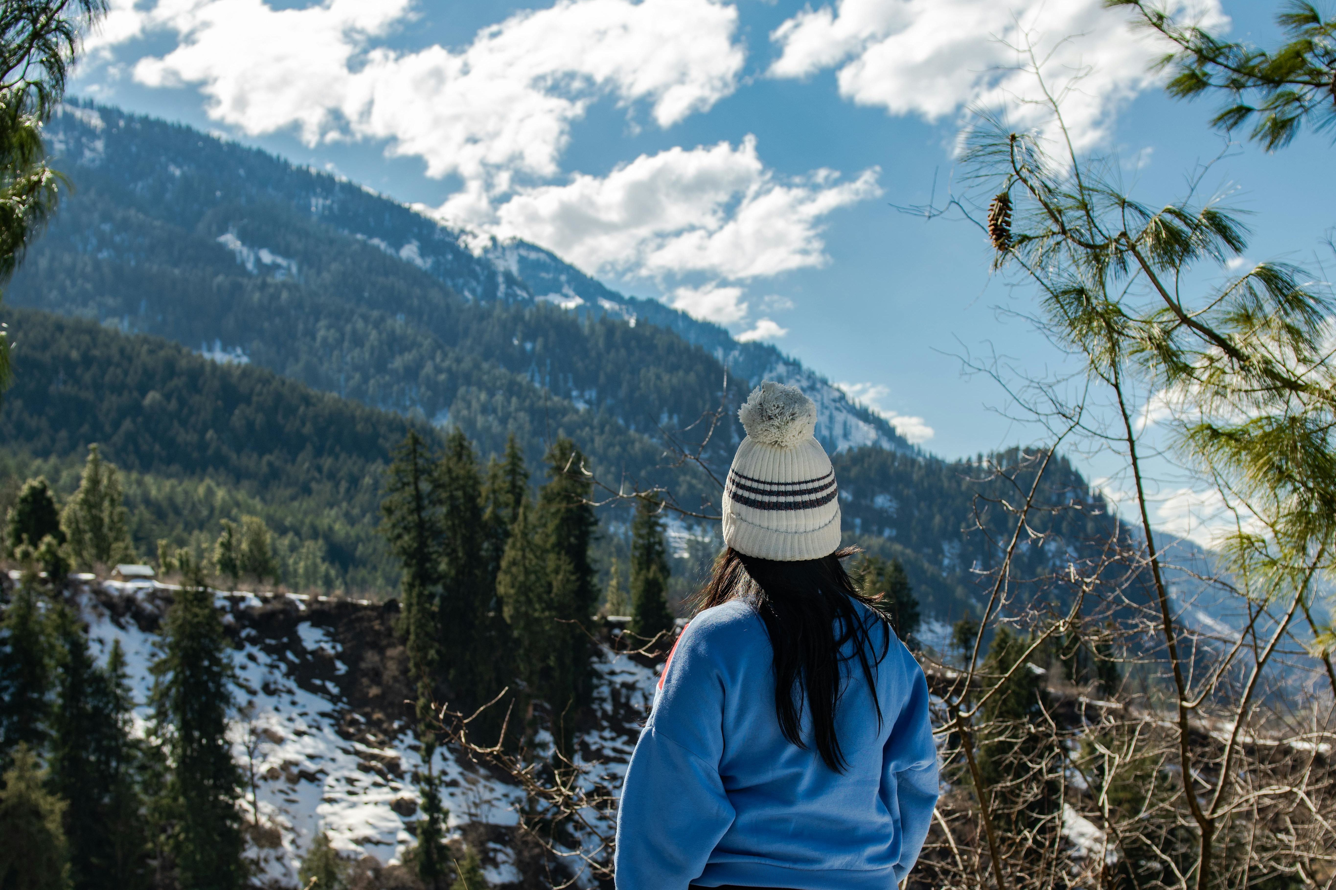 back view of a woman standing near a cliff at solang valley