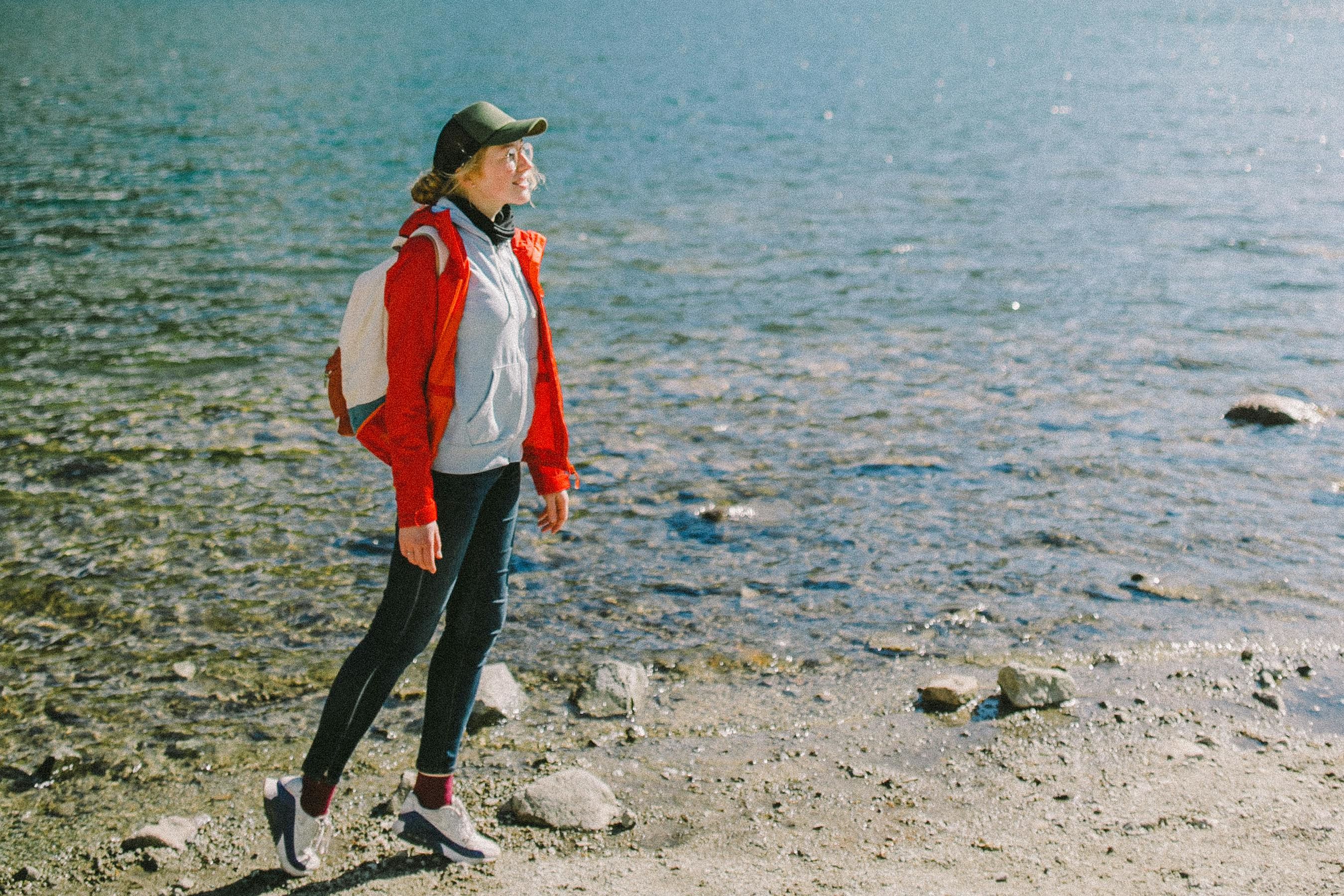 a backpacker standing on a lakeside