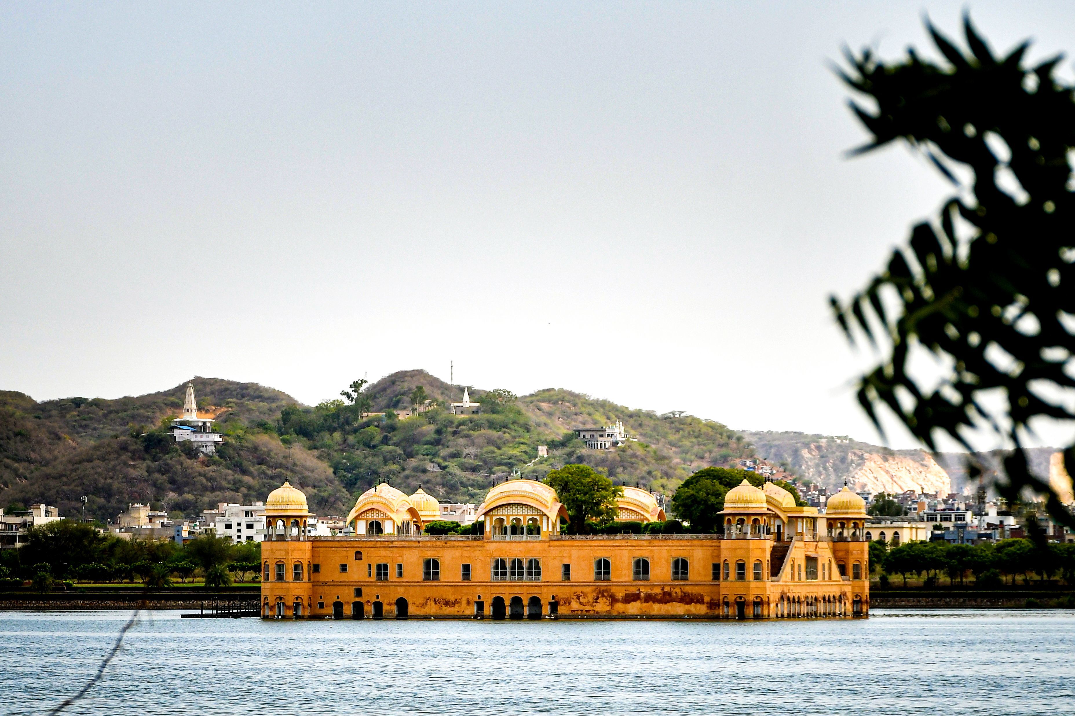 beautiful shot of jal mahal in jaipur india with scenic lake and hills in the background