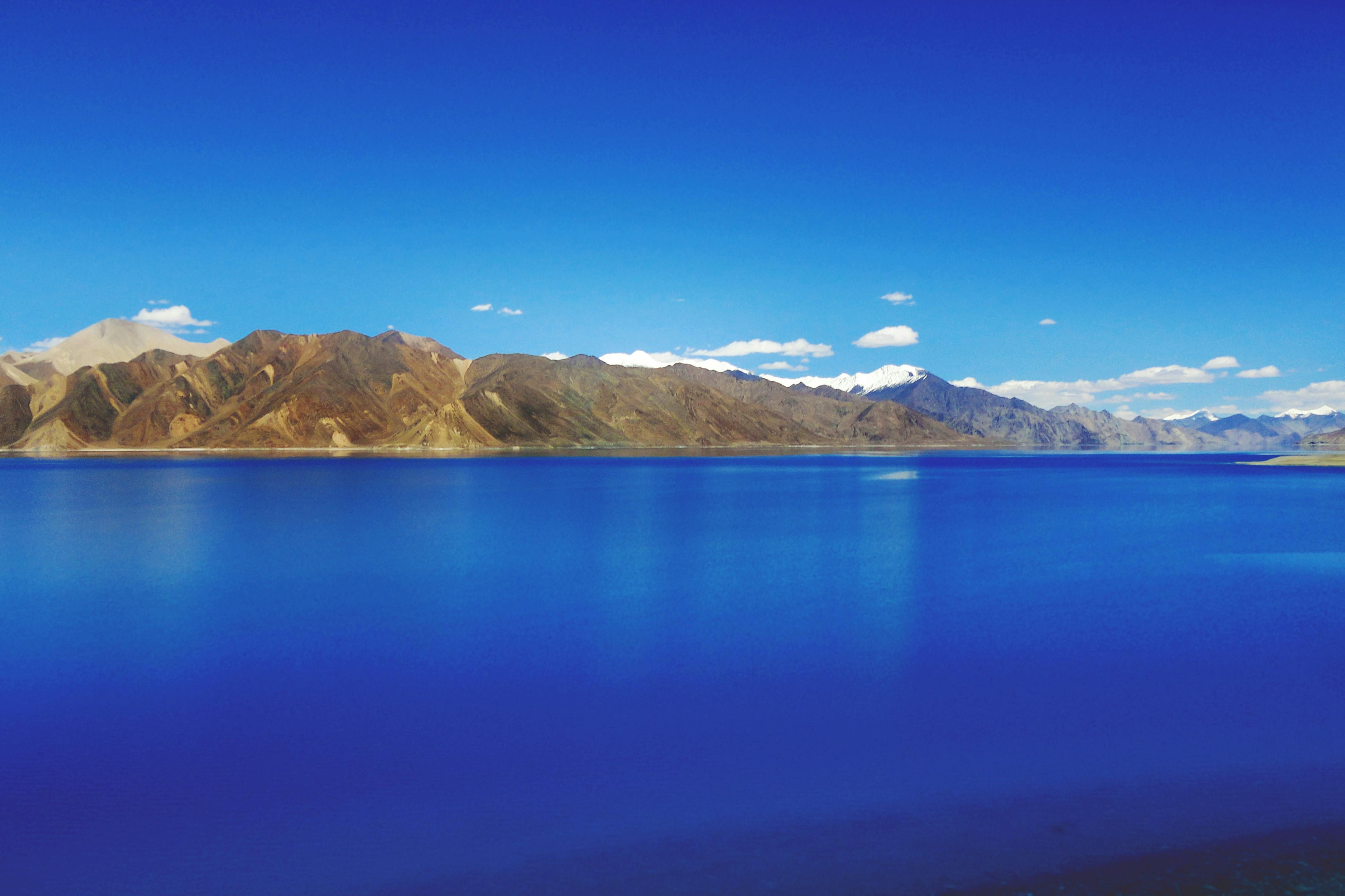 blue waters of pangong lake near mountain hills during daytime