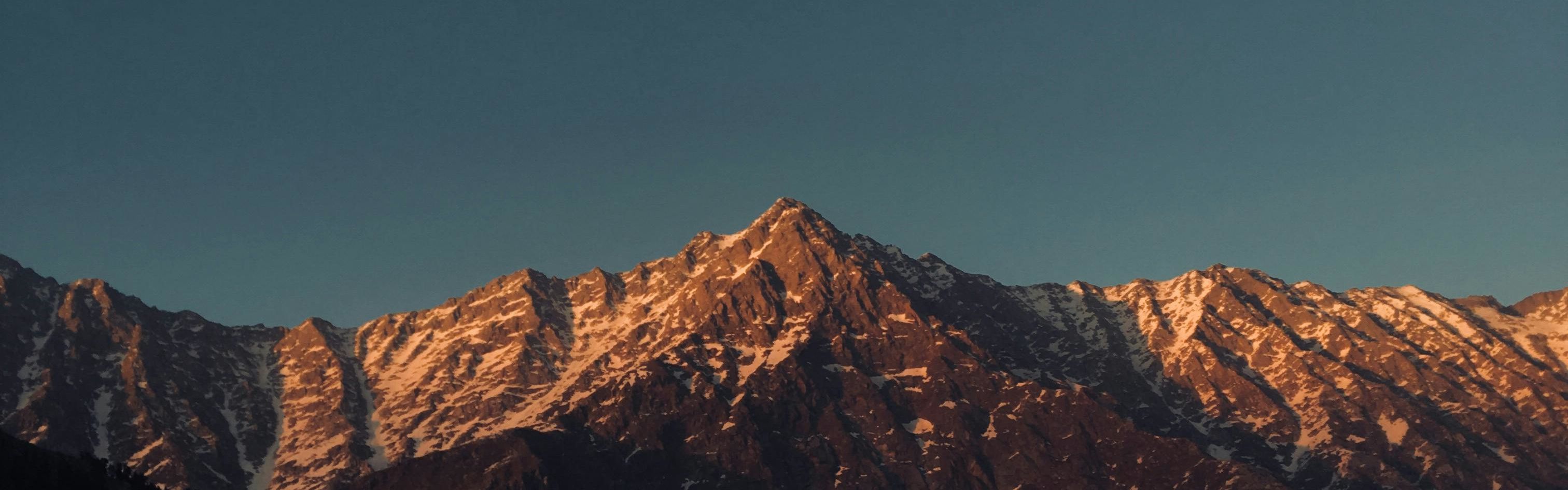 brown rocky mountain under the blue sky in himachal pradesh