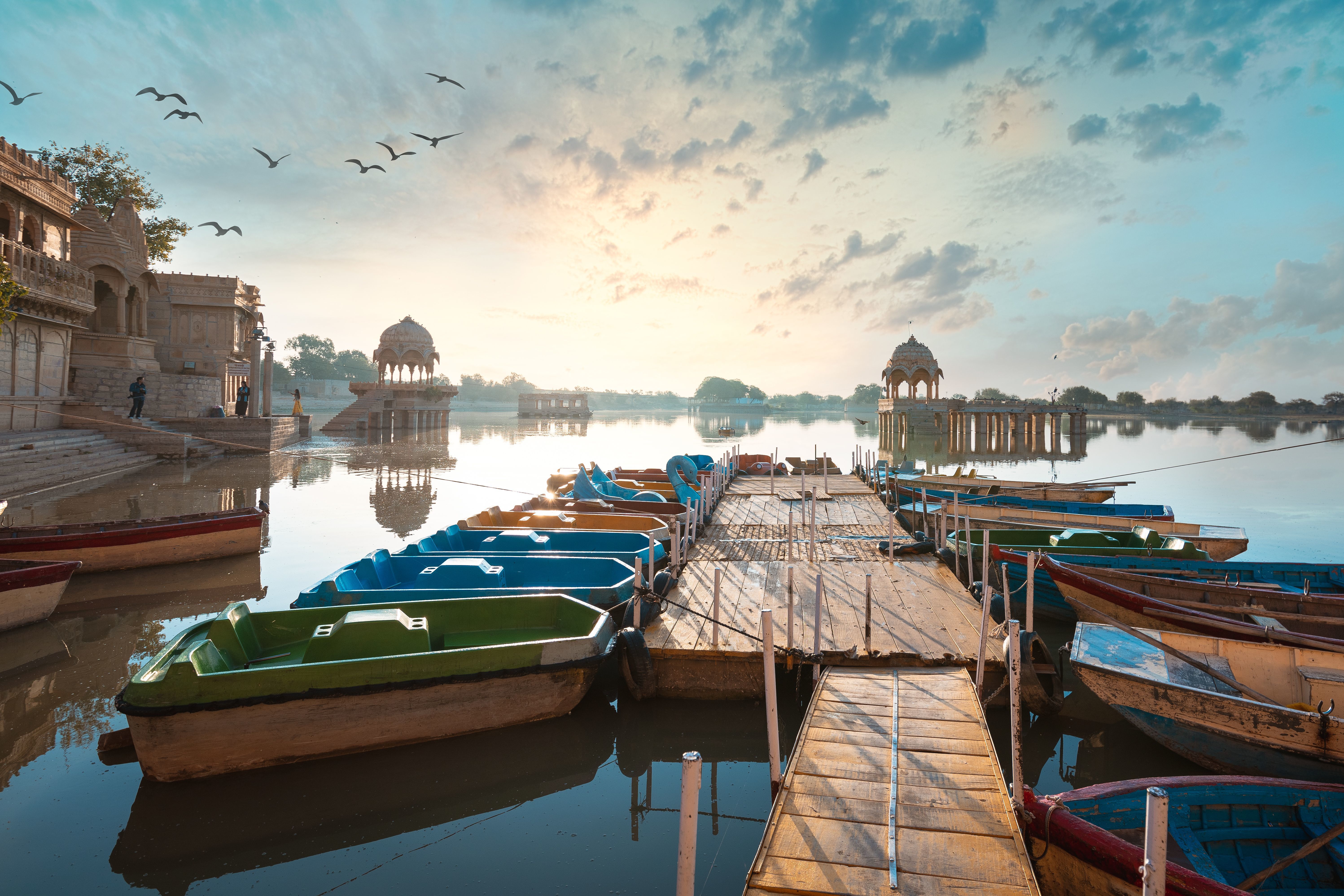 colorful boats docked at gadisar lake with scenic sunset in jaisalmer