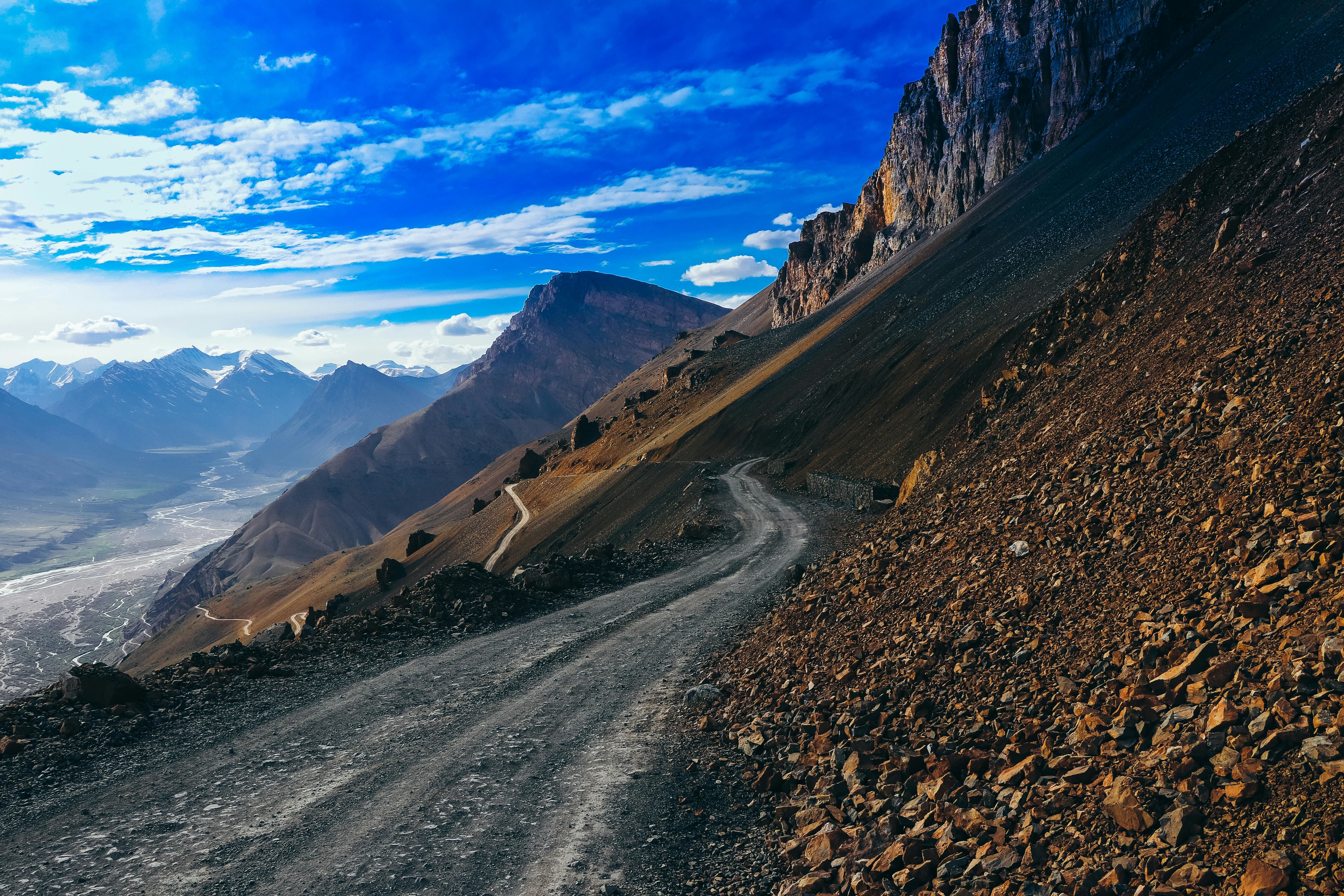 dirt road near brown mountains under beautiful sky in hikkim himachal pradesh