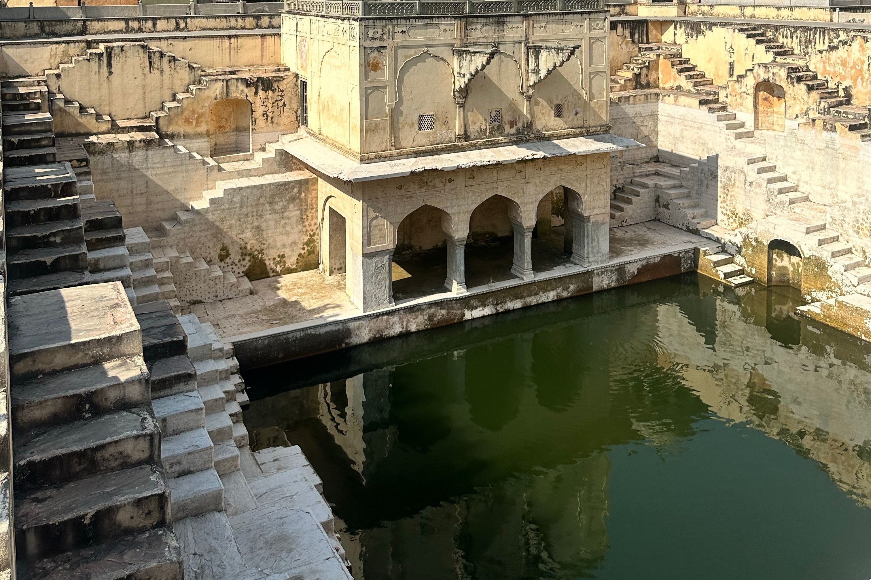 a historic stepwell with reflective water in bundi in rajasthan
