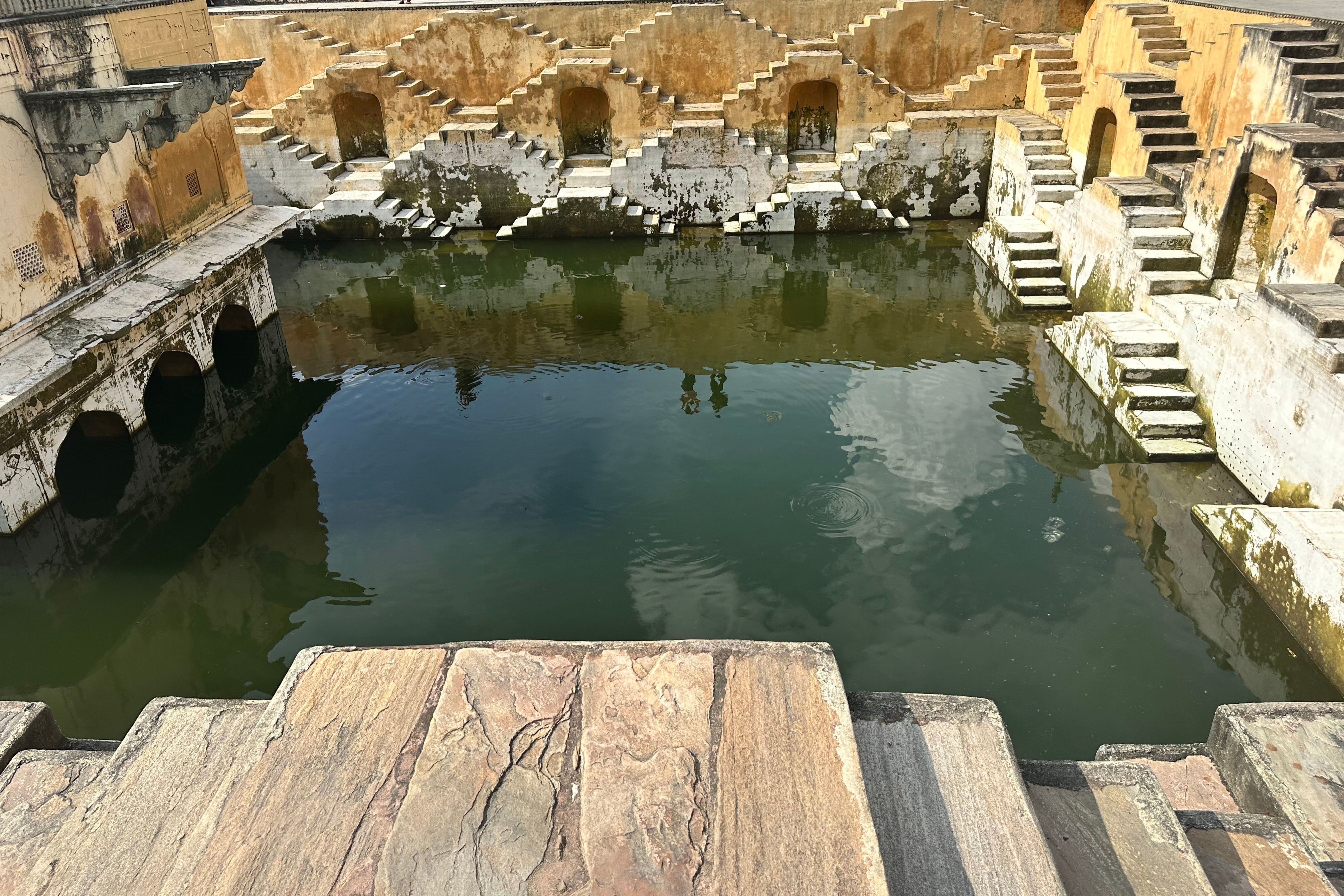 a historic stepwell with reflective water in bundi in rajasthan
