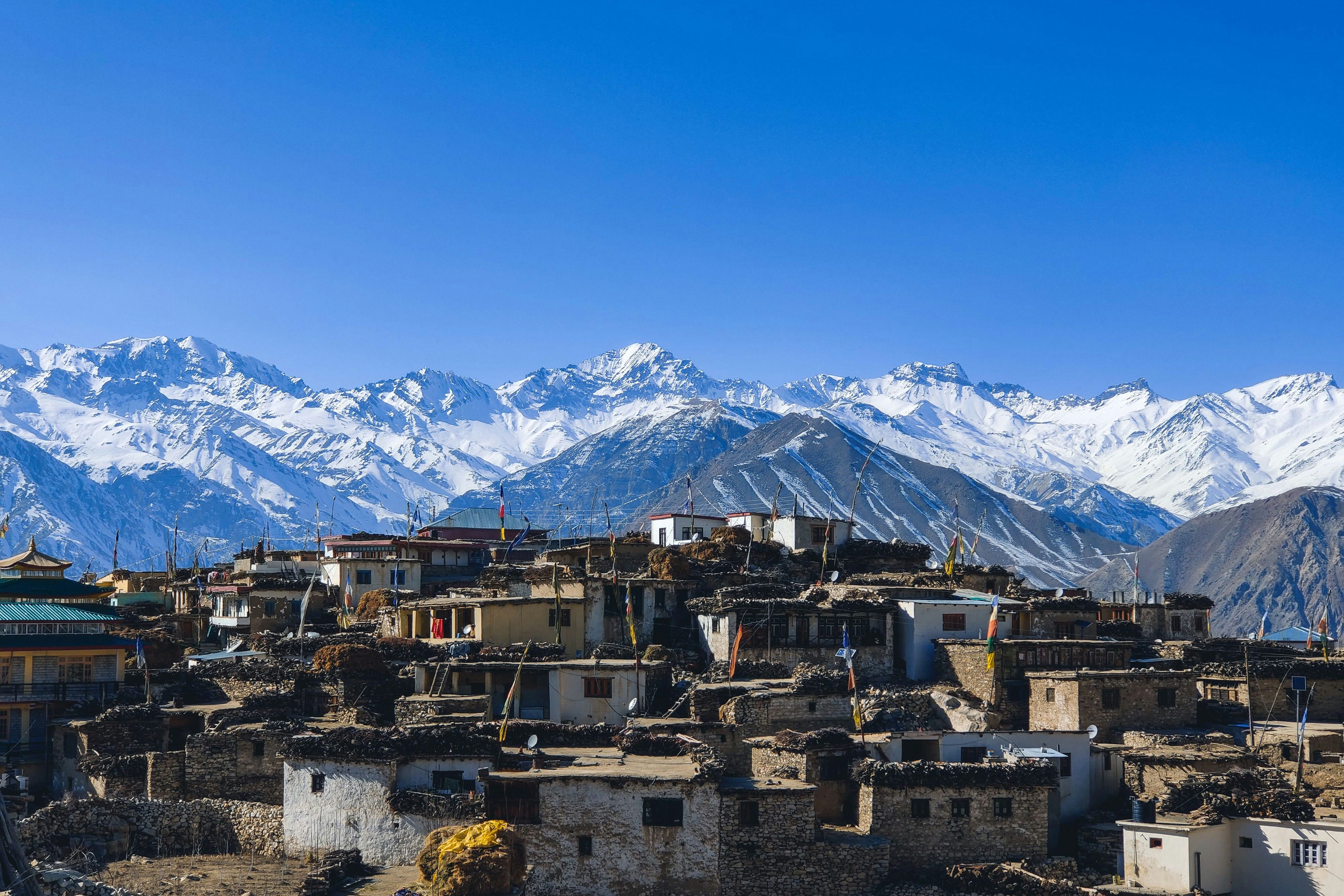 houses near snow covered mountain range during daytime in nako village