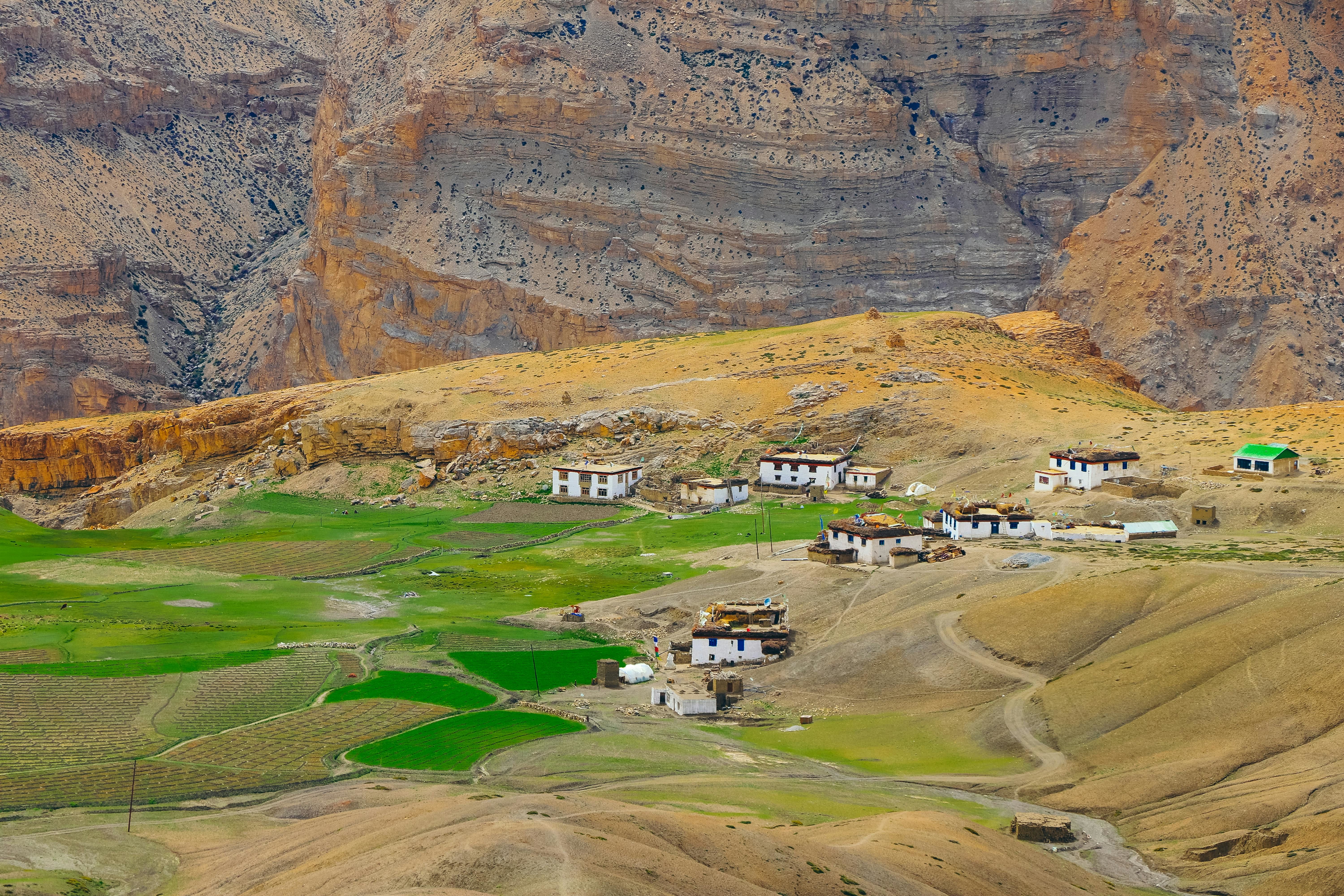 houses in langza village surrounded by brown coloured mountains