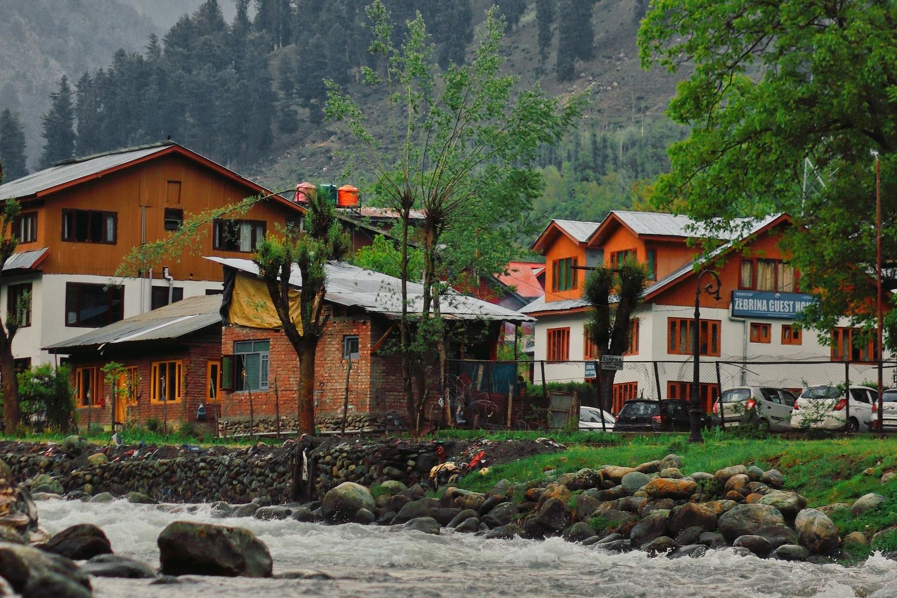 houses on the bank of beas river in manali