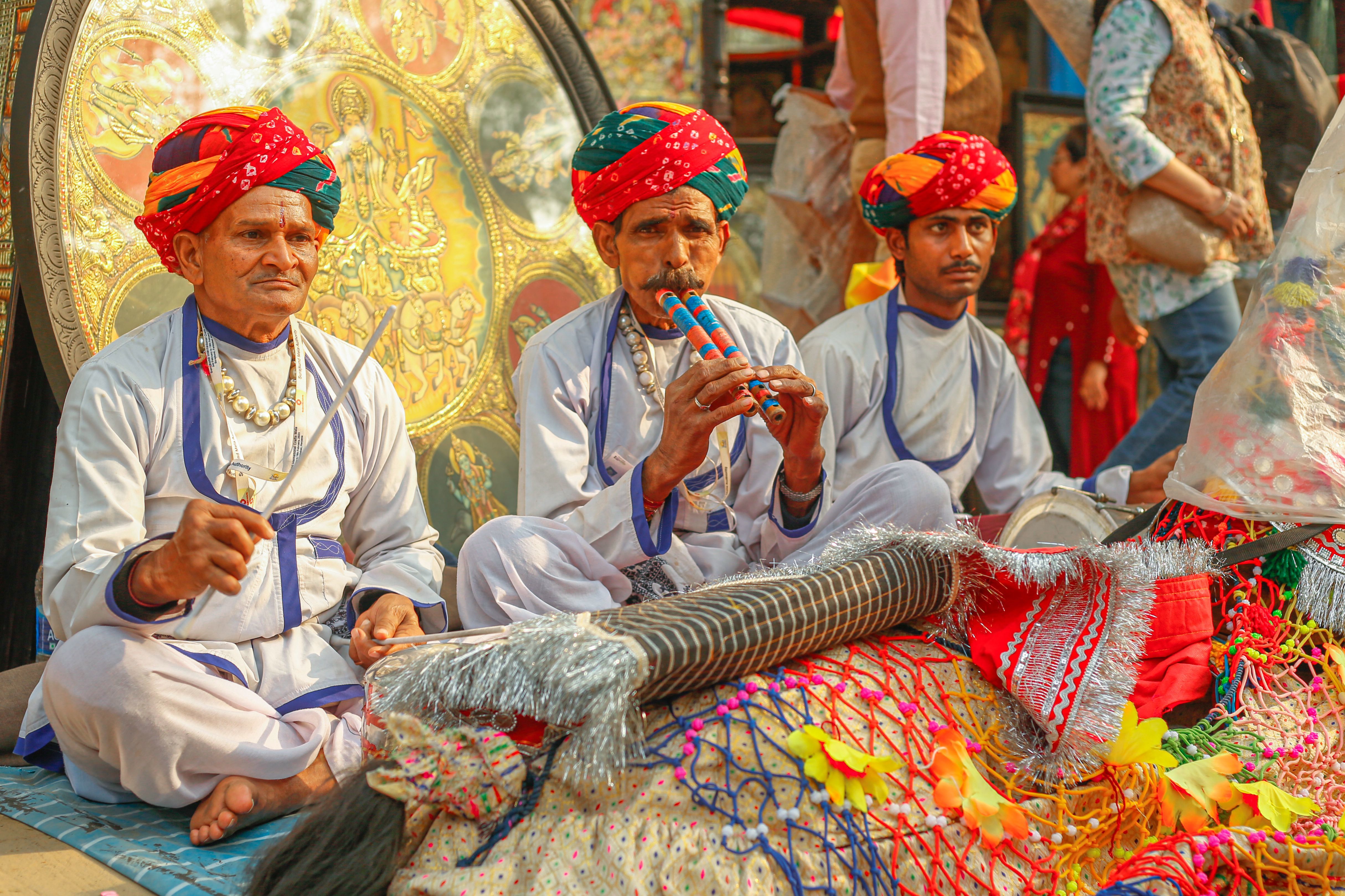 men in traditional rajasthani clothing sitting cross legged at a cultural festival