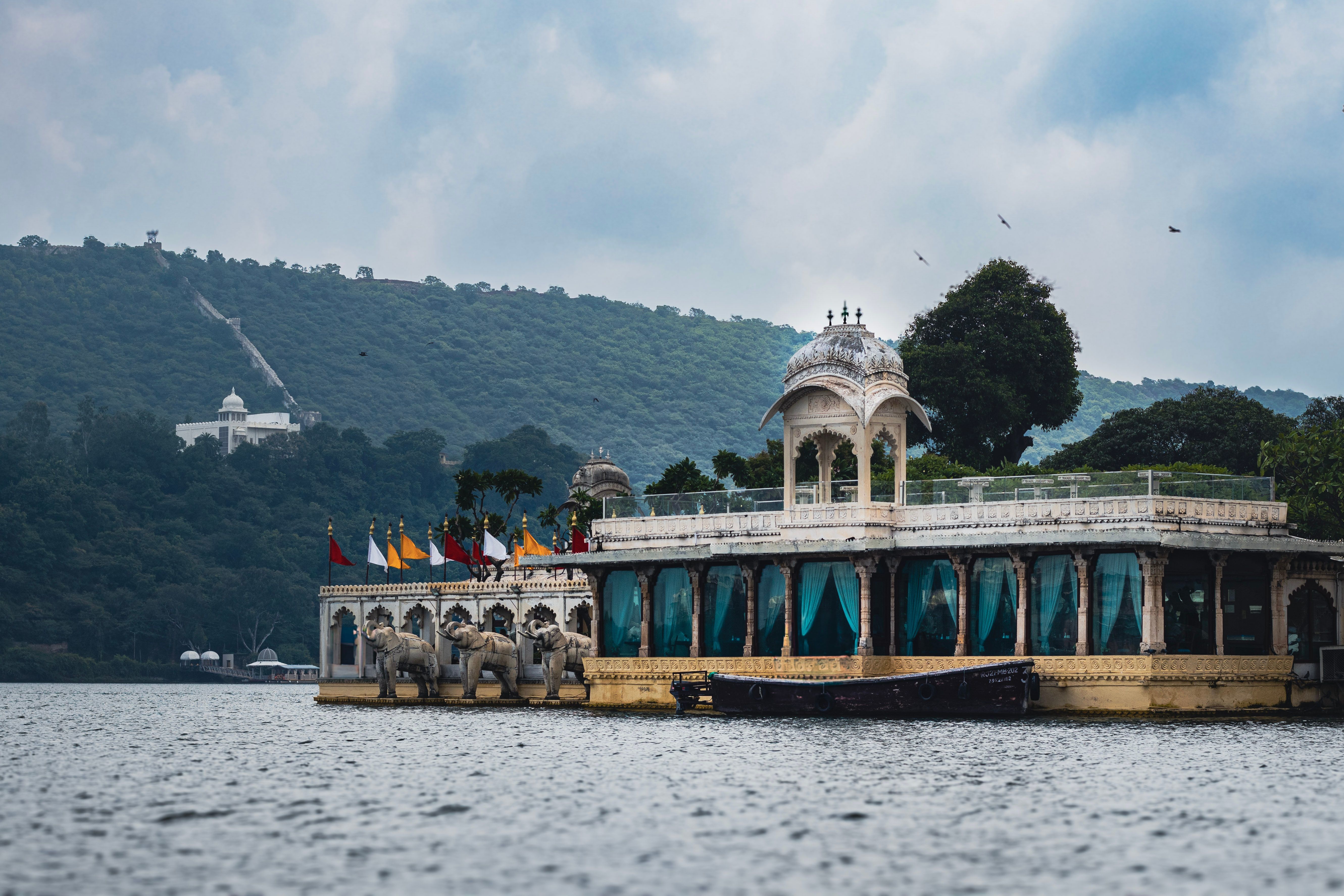 jag mandir palace in udaipur with green mountains in the backdrop