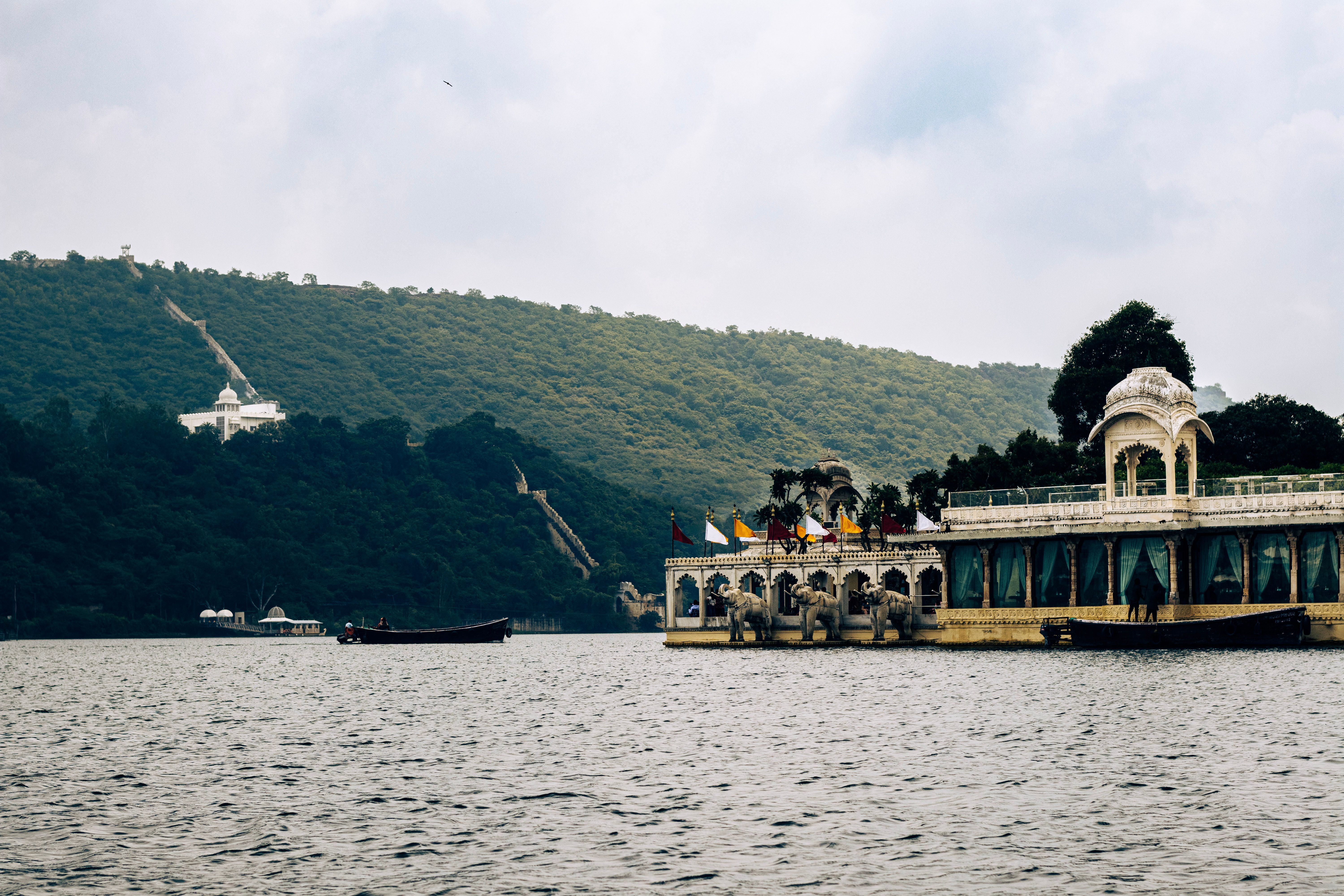 jag mandir palace in udaipur with green mountains in the backdrop