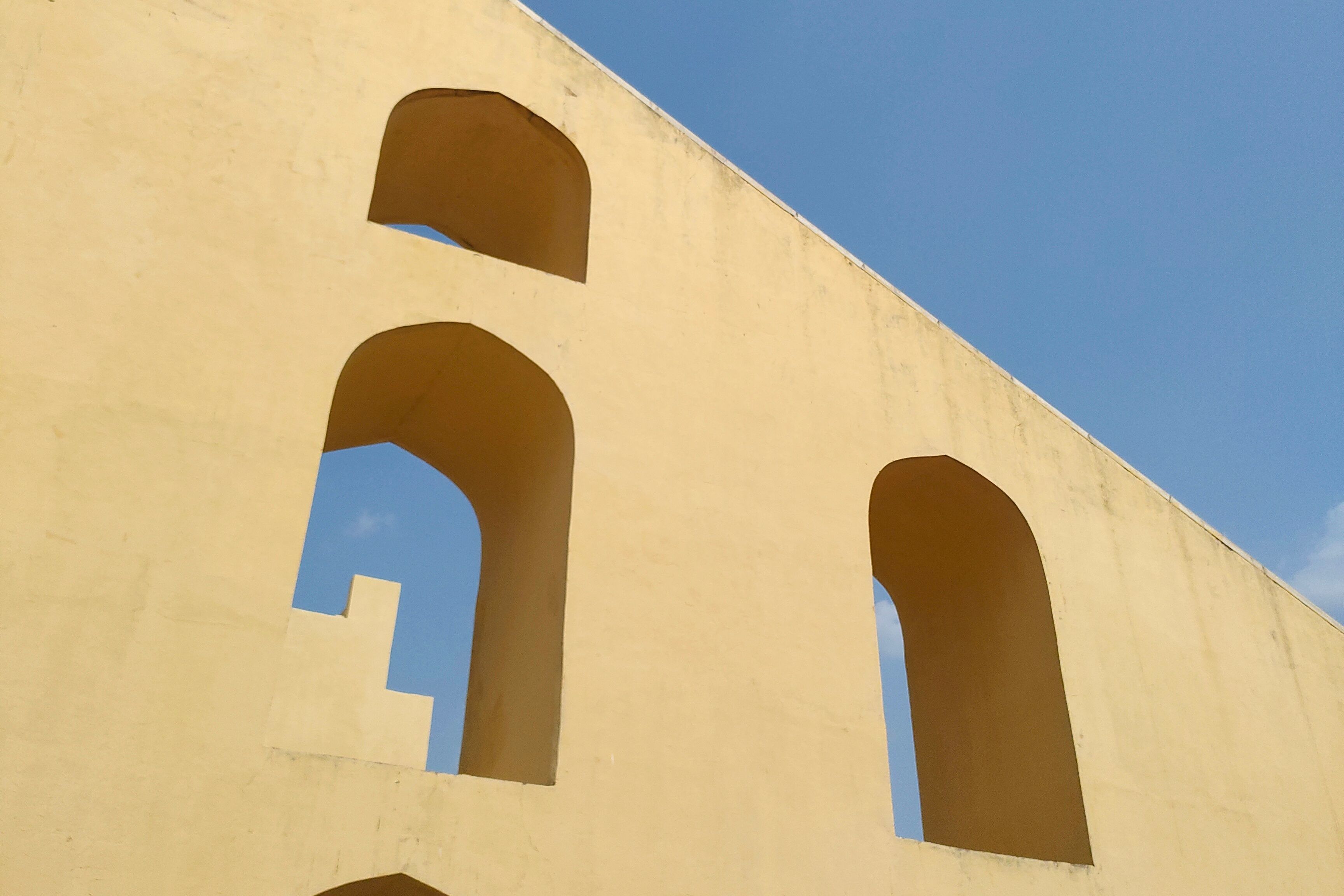 view of jantar mantar arches under blue sky and clouds at jantar mantar