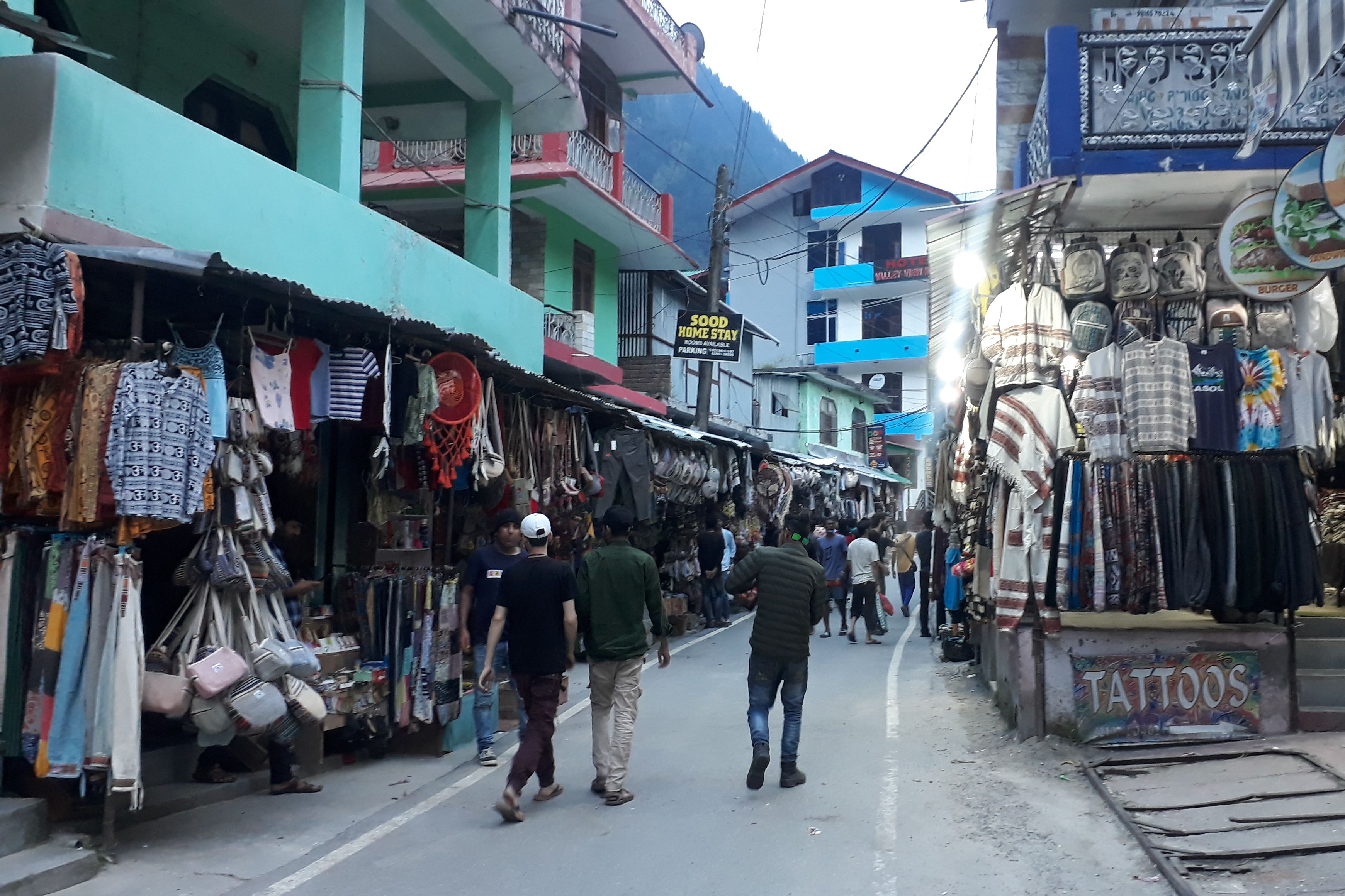 tourists walking in kasol market during daytime