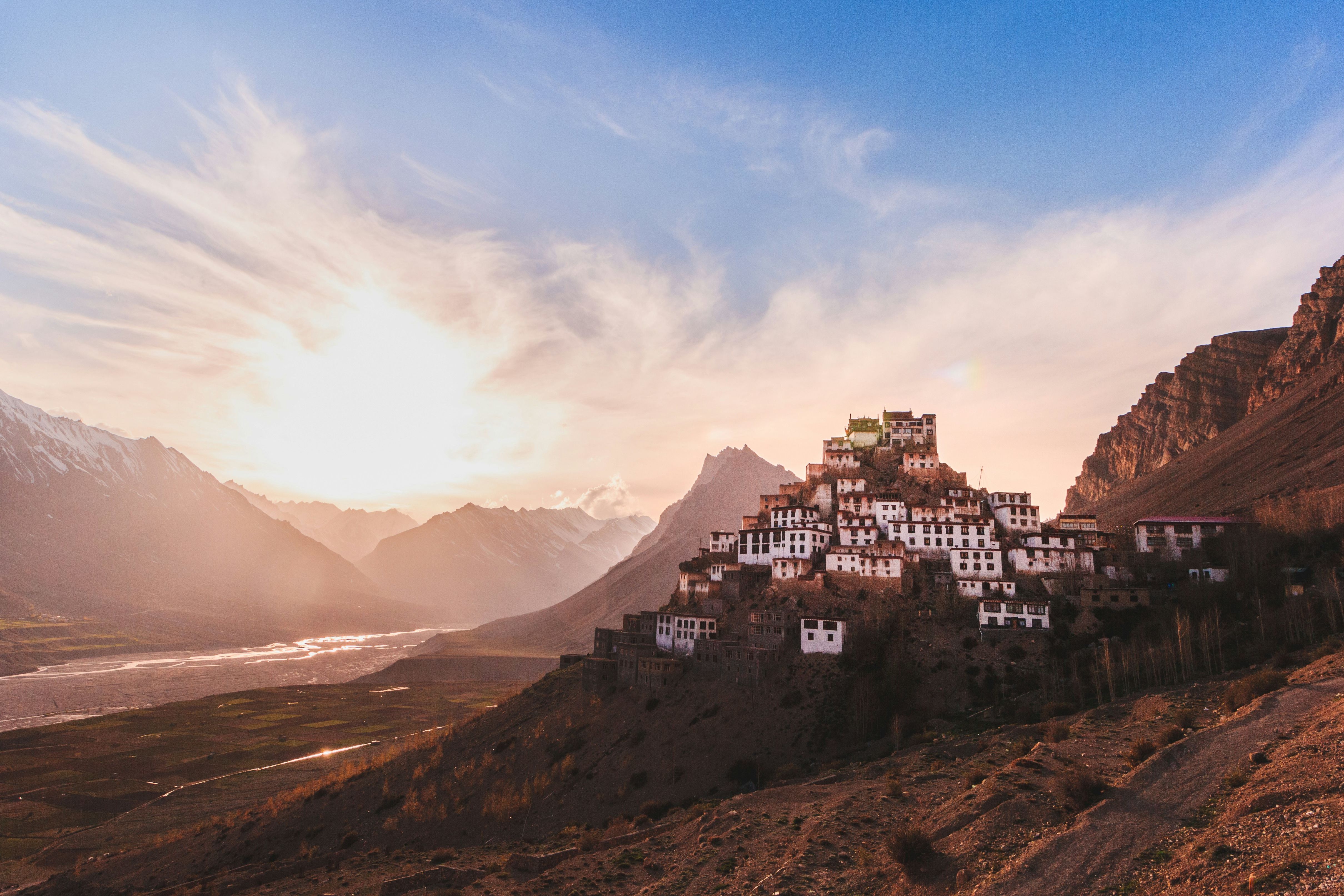 view of key monastery near mountain under white clouds during daytime