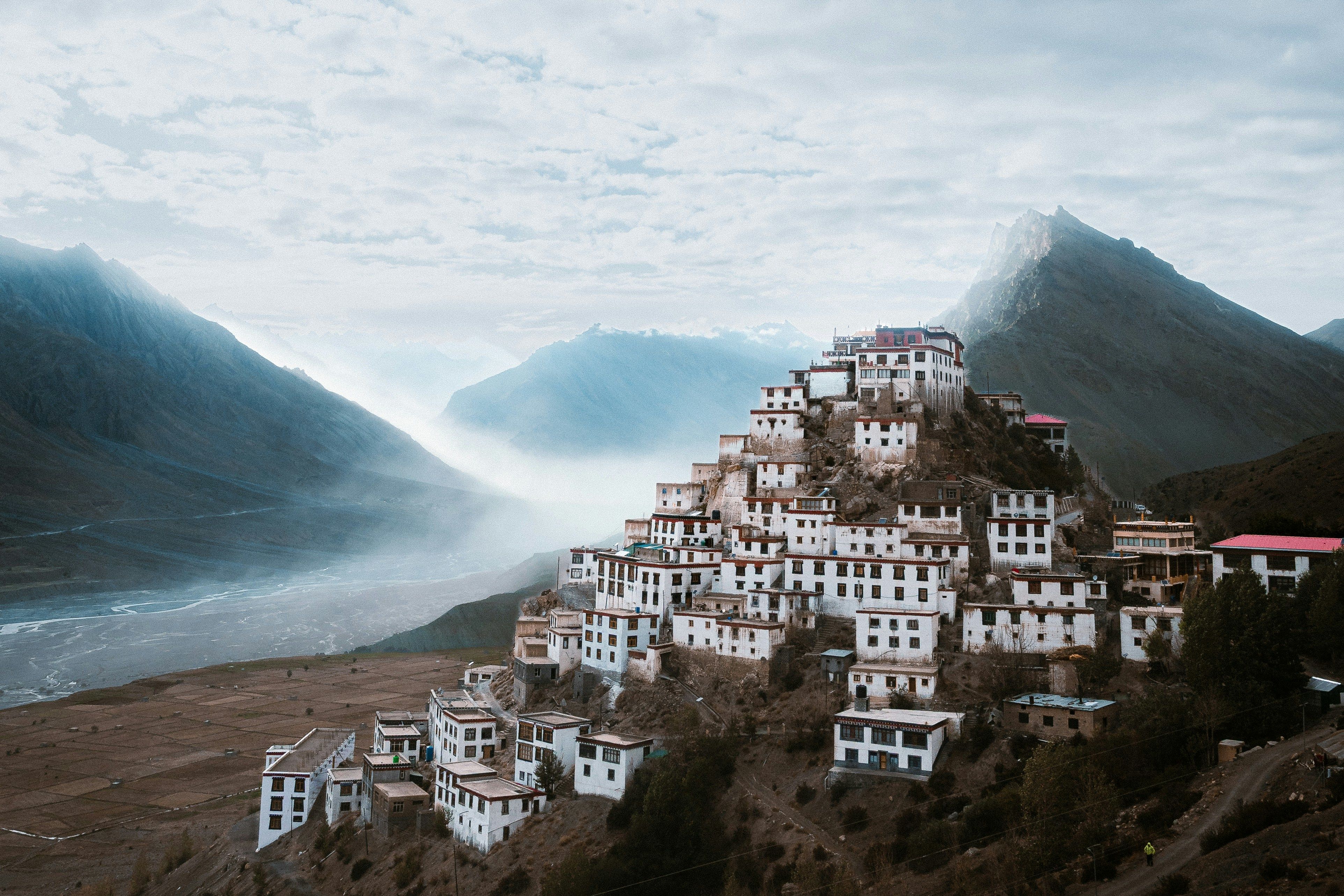 view of key monastery with brown mountains and clouds in the background