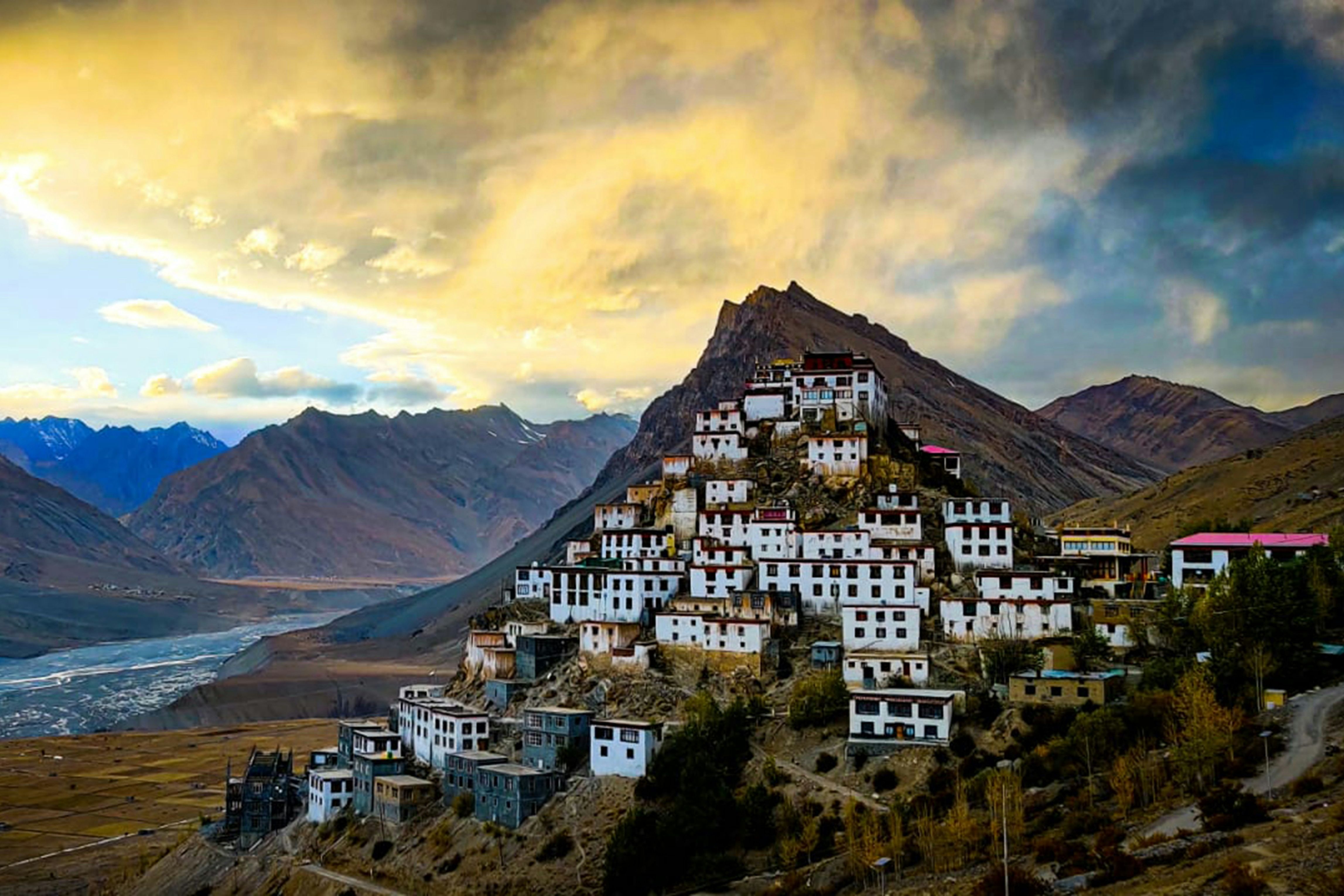 view of key monastery with brown mountains and clouds in the background during evening time