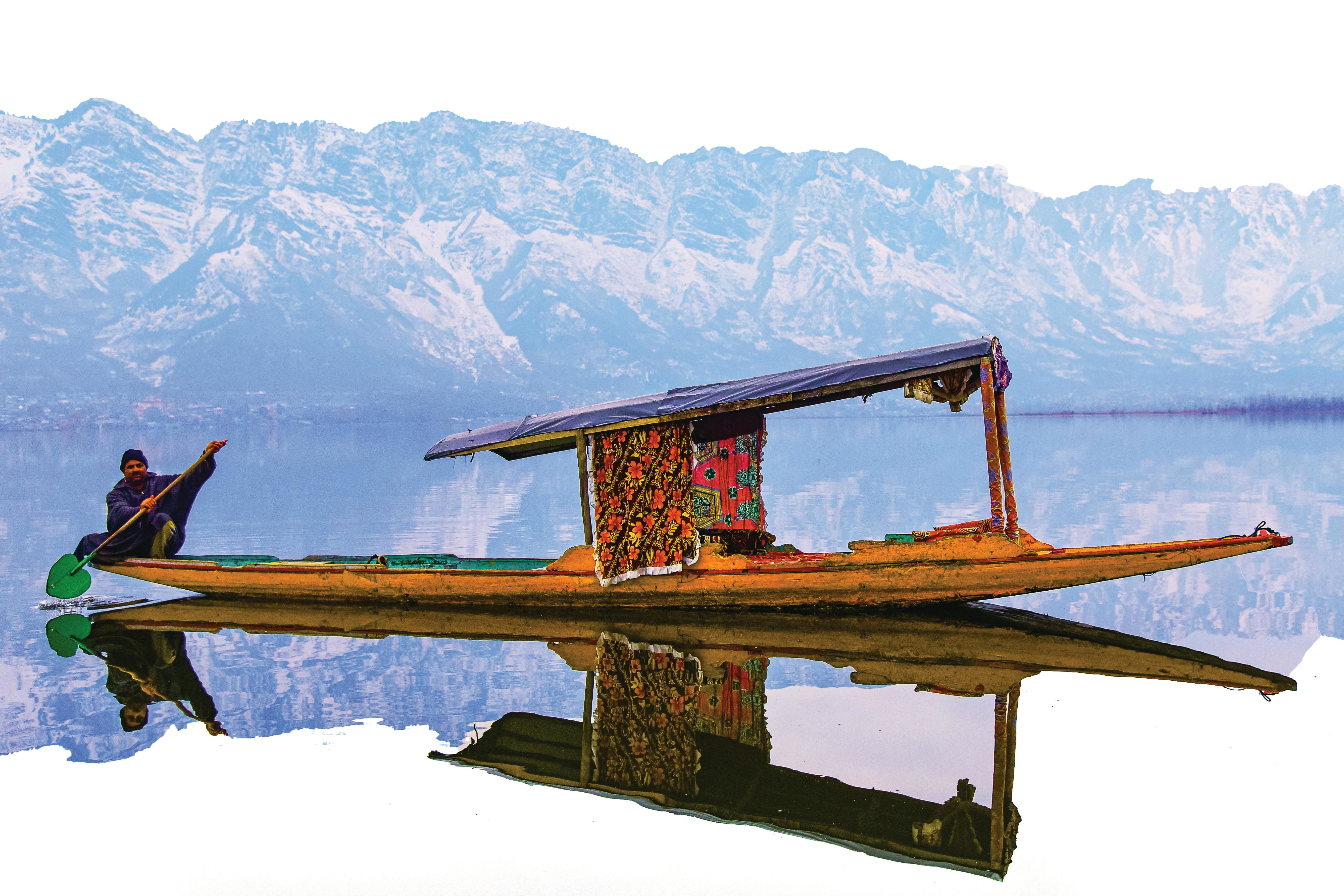 a man on a shikara boat on dal lake in srinagar