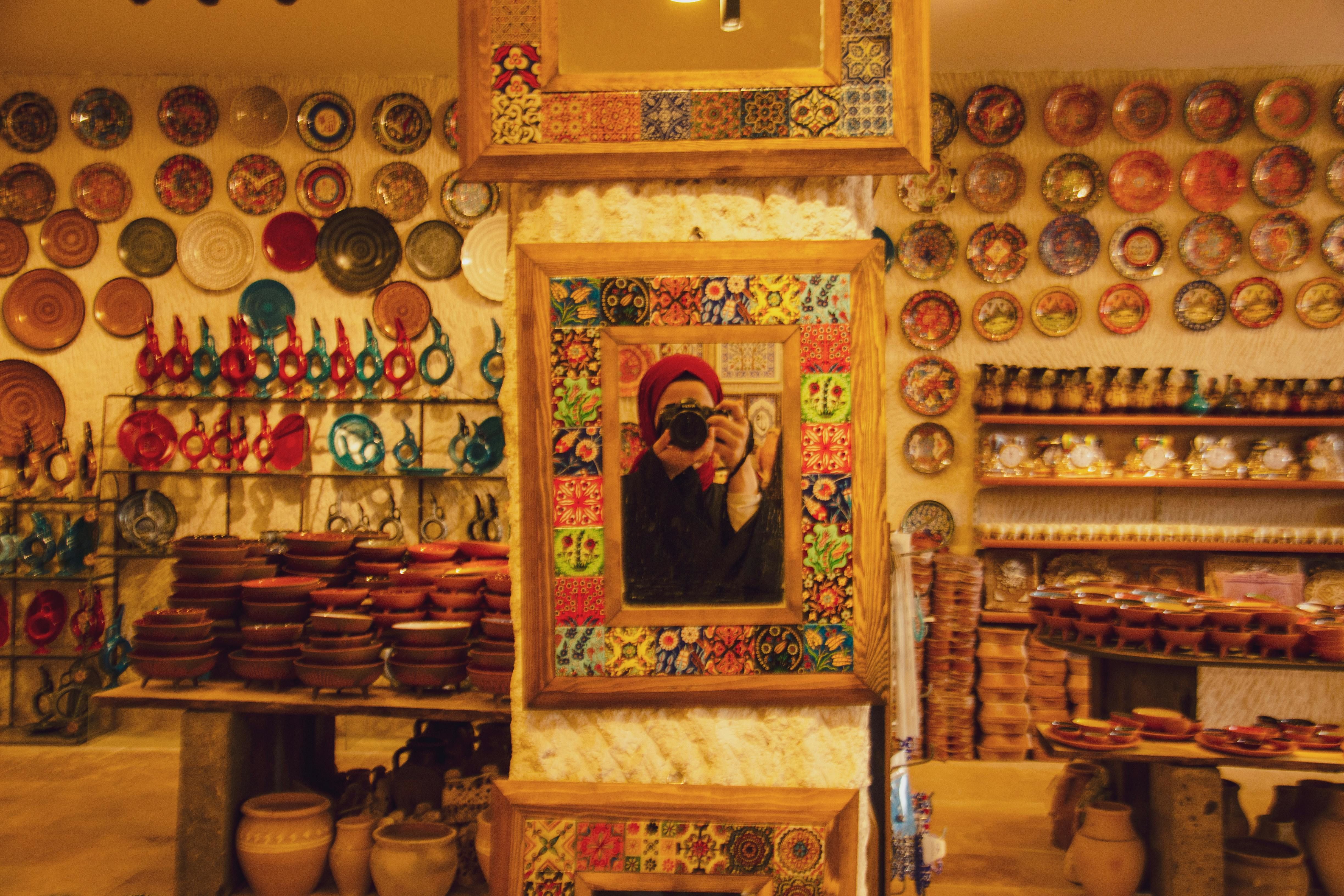 man reflecting in mirror in pottery store
