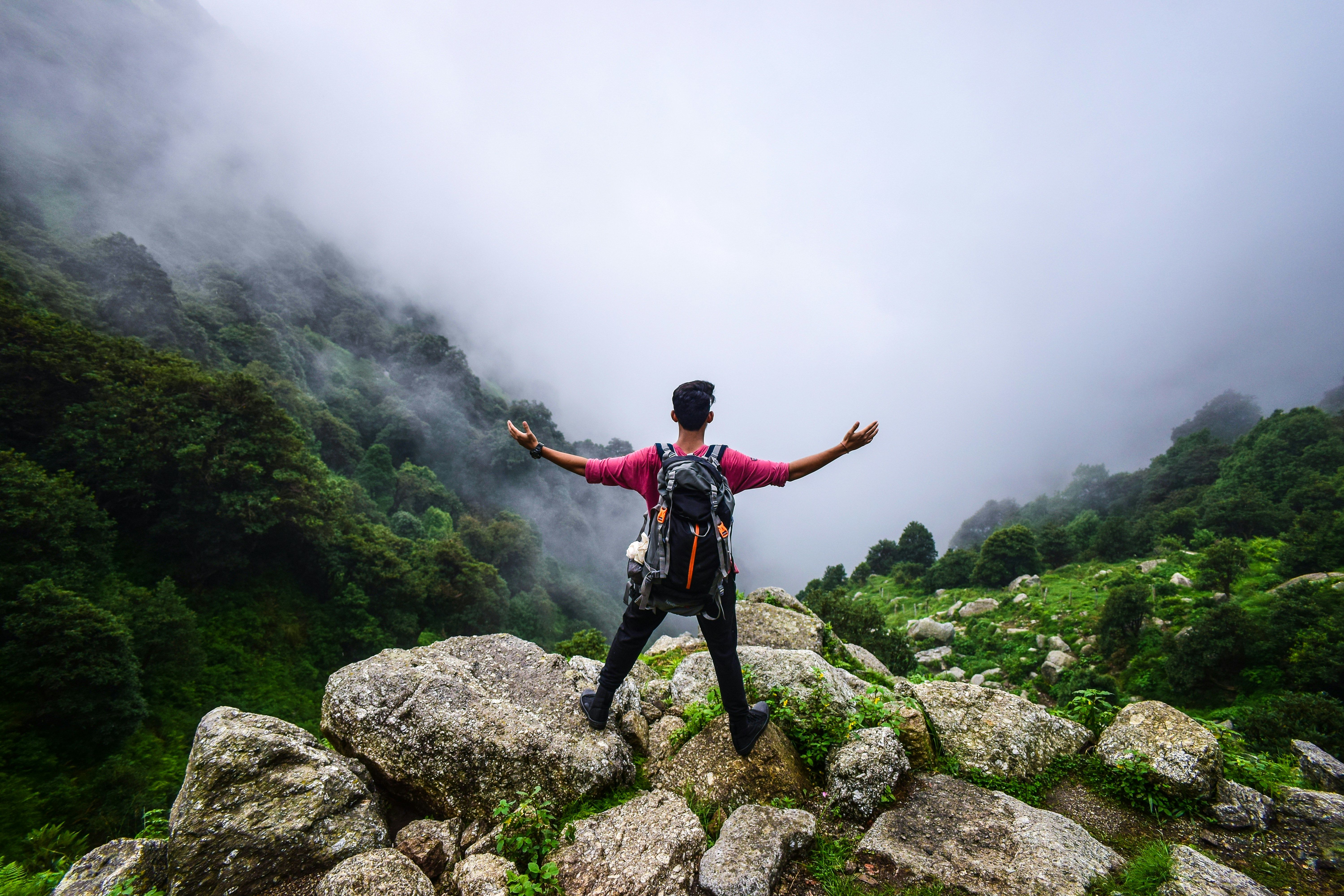 a man standing on a mountain in tirthan valley