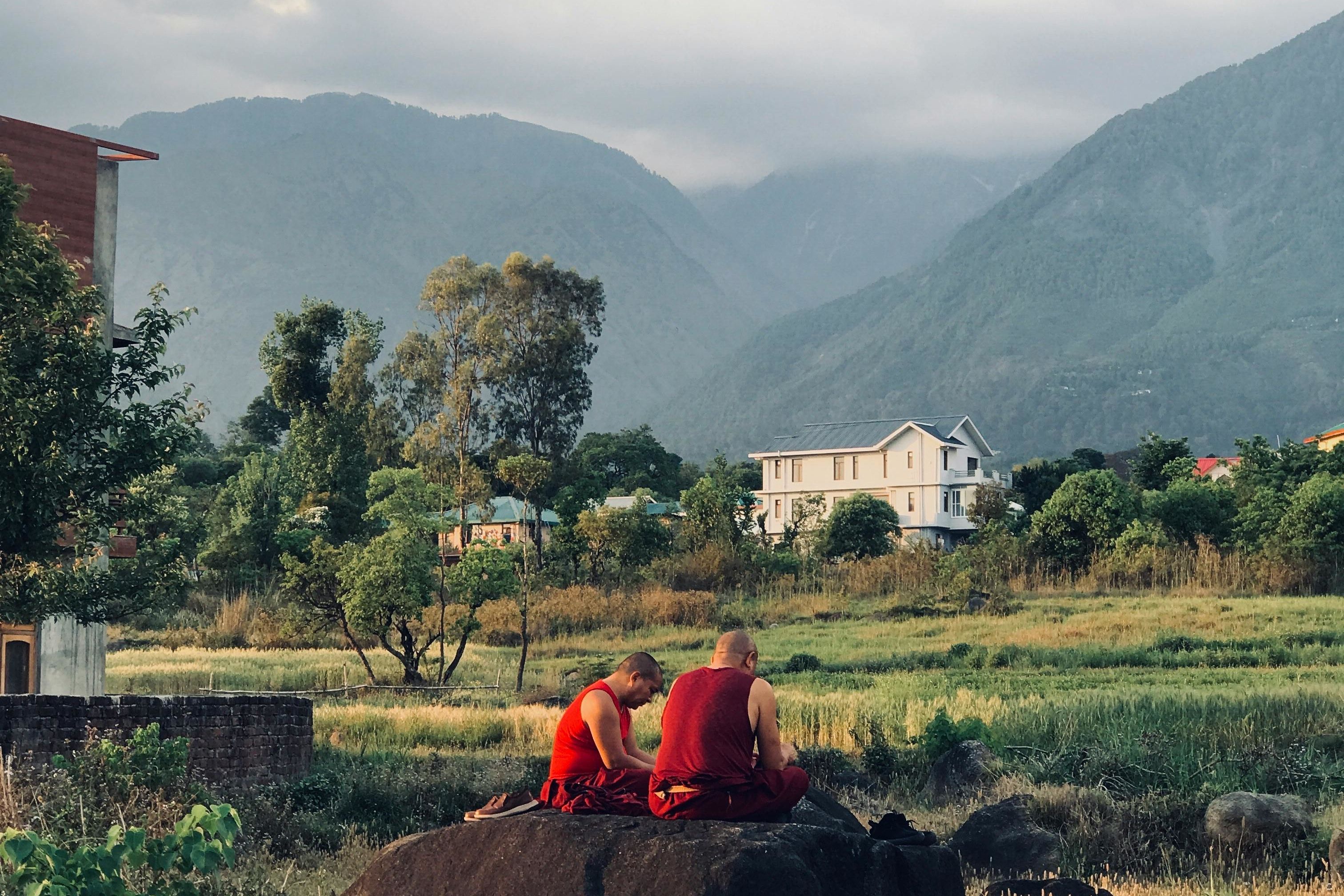 monks sitting in middle of the himalayan region in dharamshala