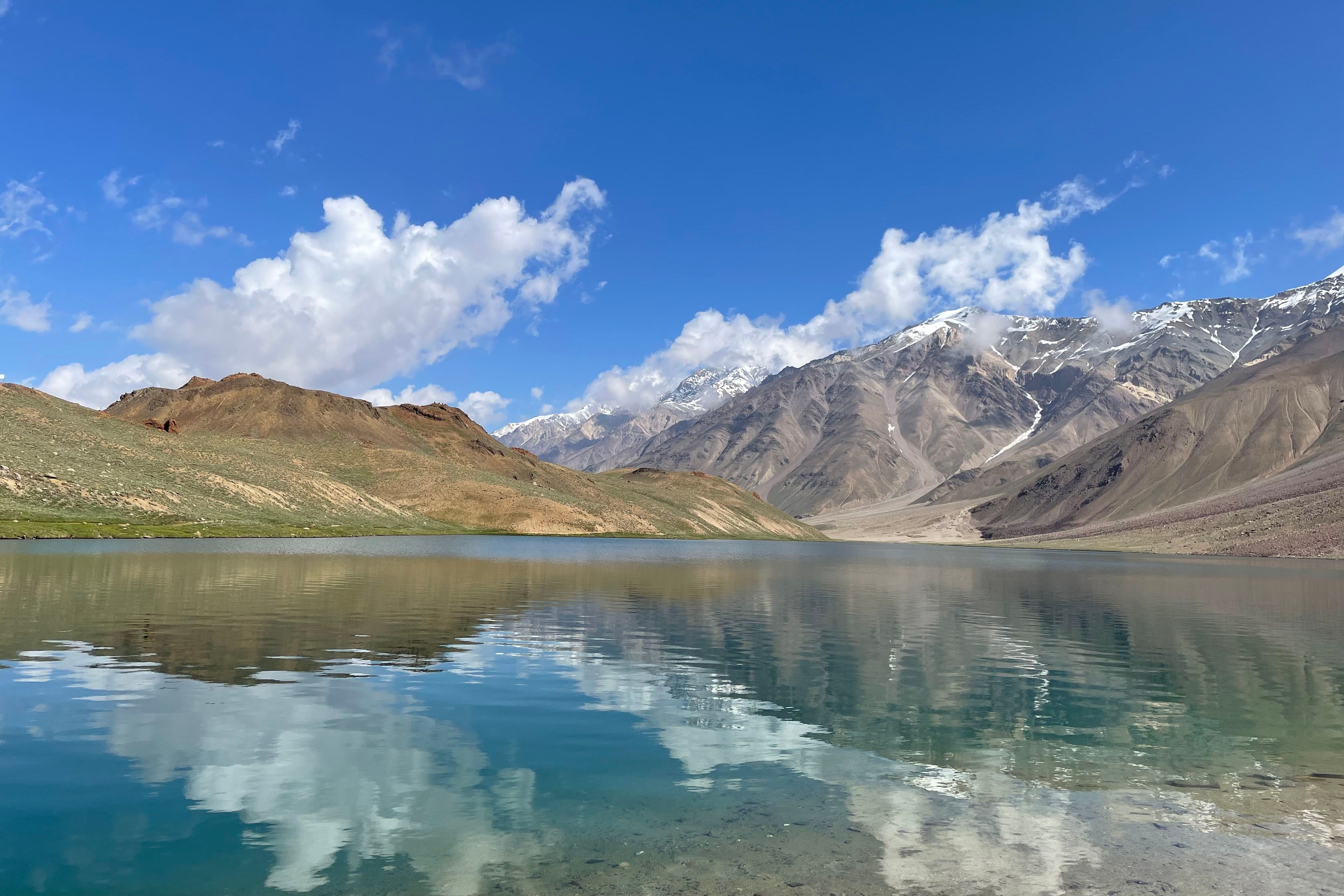 reflection of mountains on the surface of chandratal lake in spiti valley