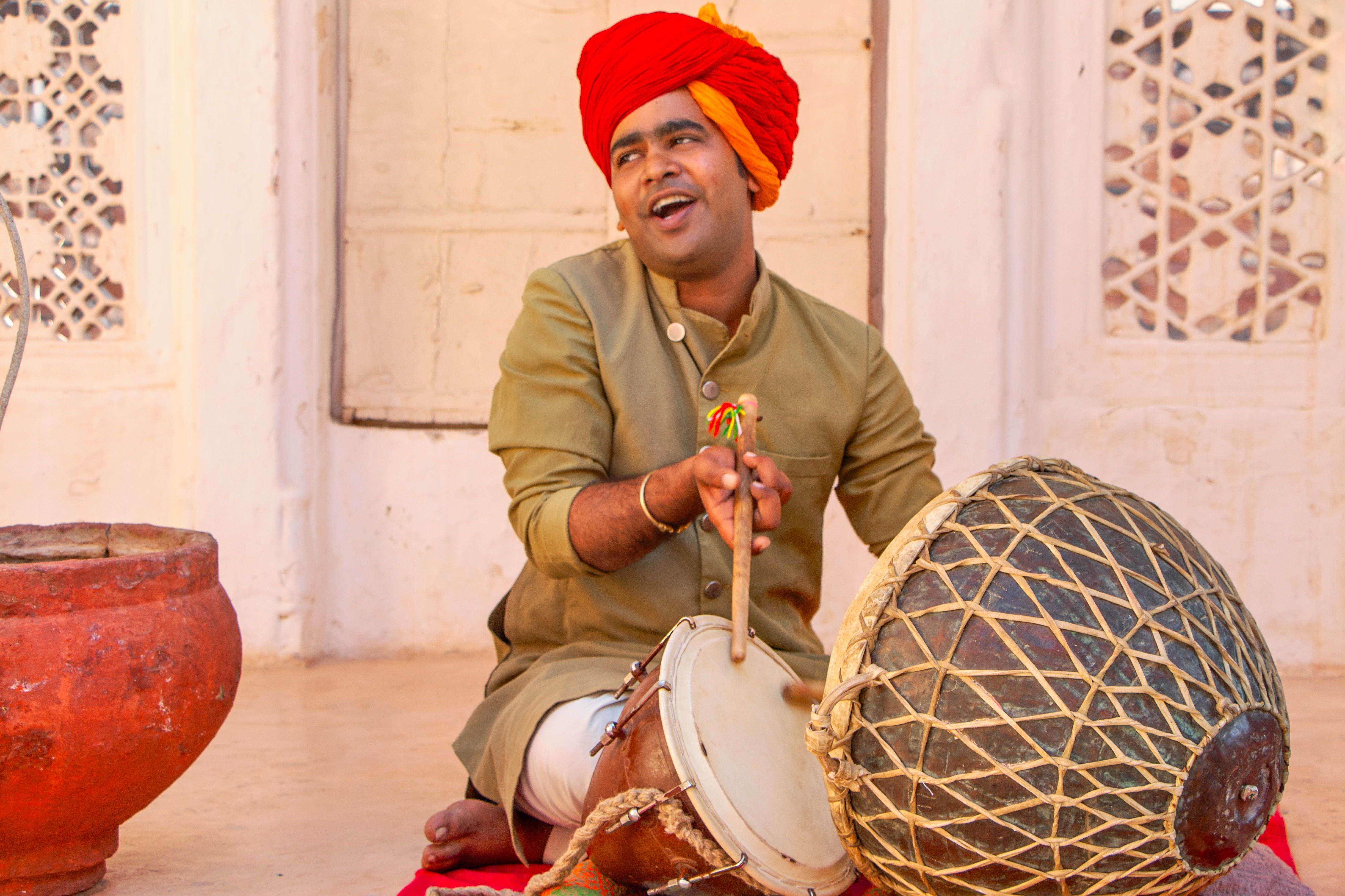musicians in vibrant attire playing traditional drums outdoors
