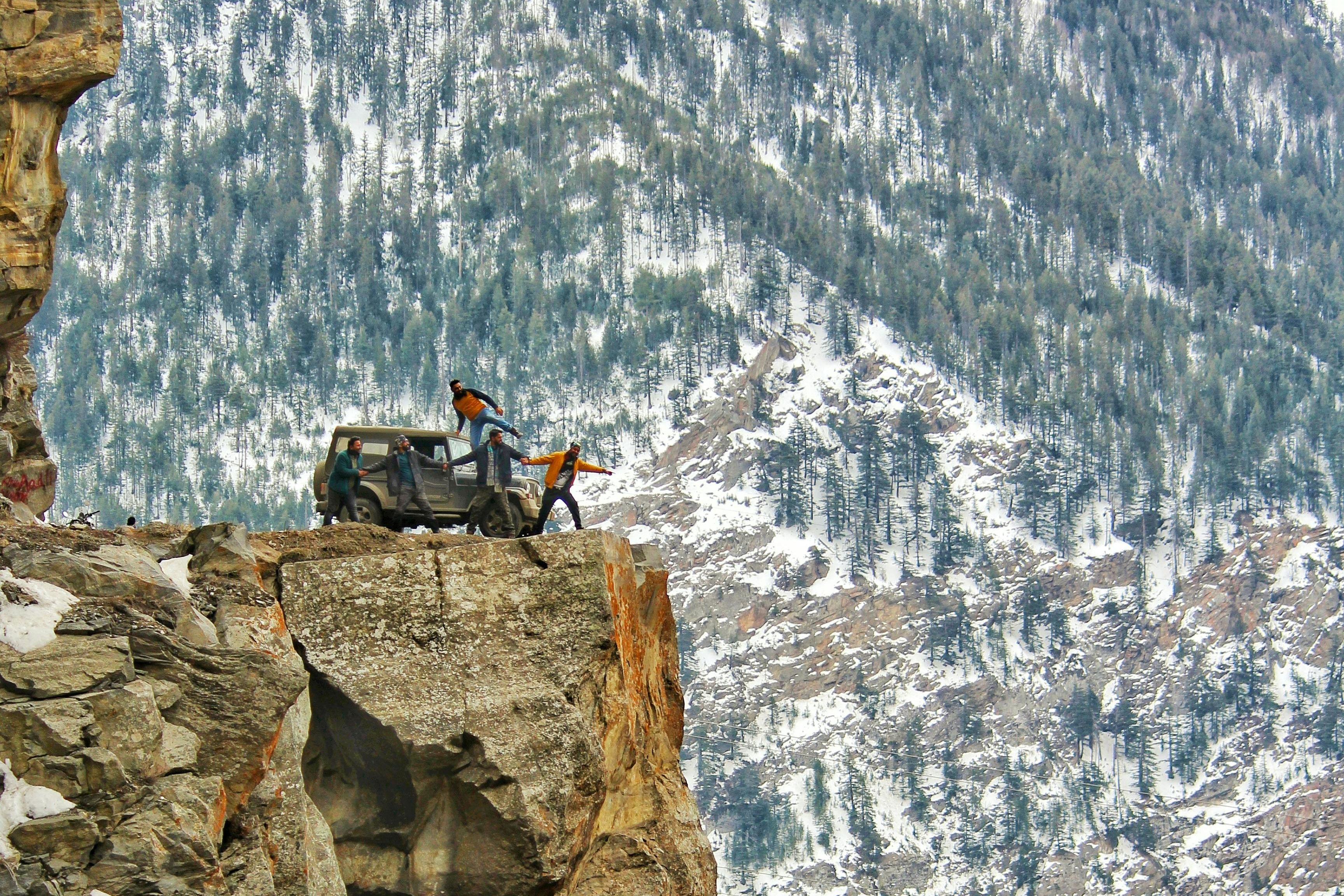 people standing on the rock edge near kalpa valley
