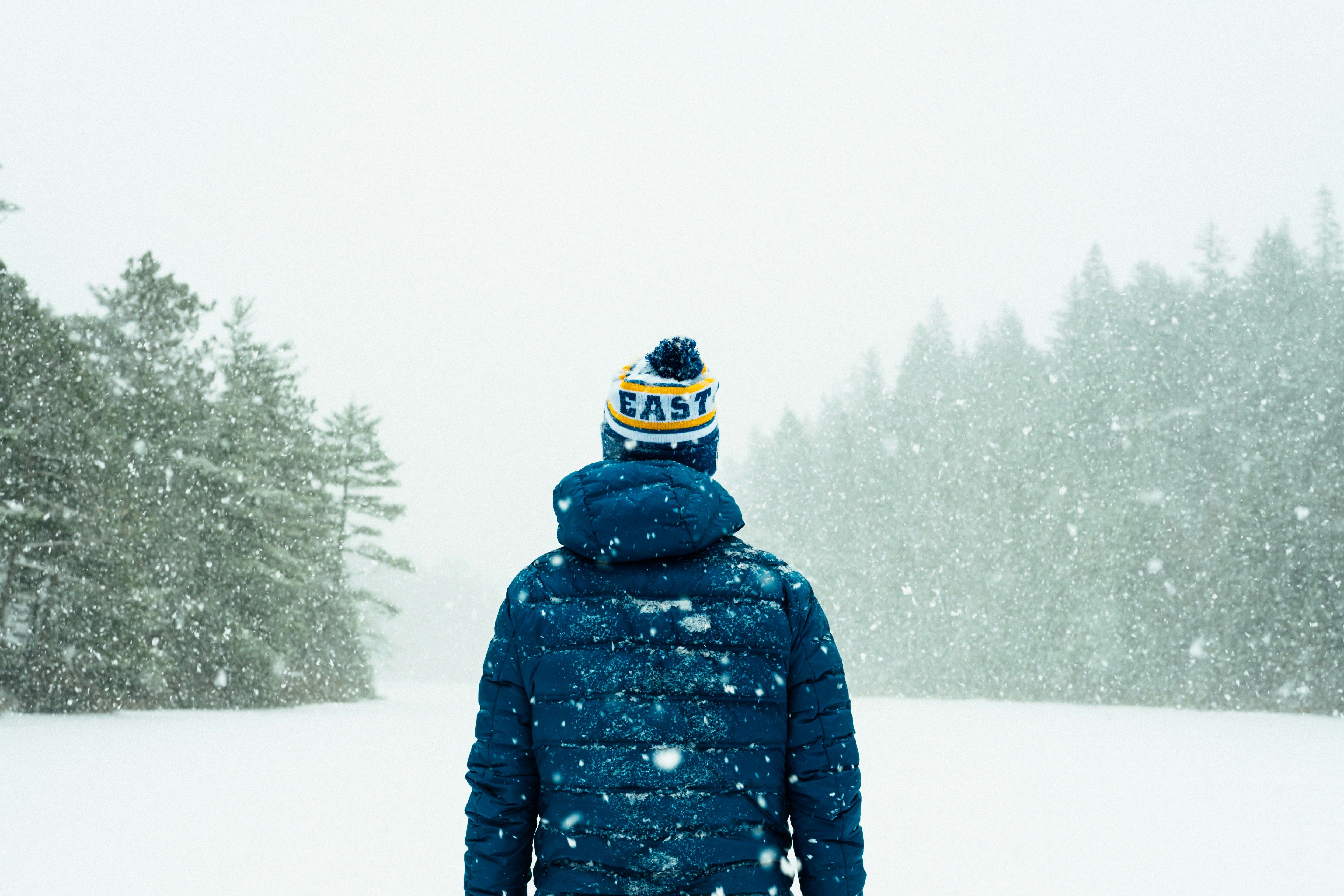 a person in blue jacket standing on snow covered ground