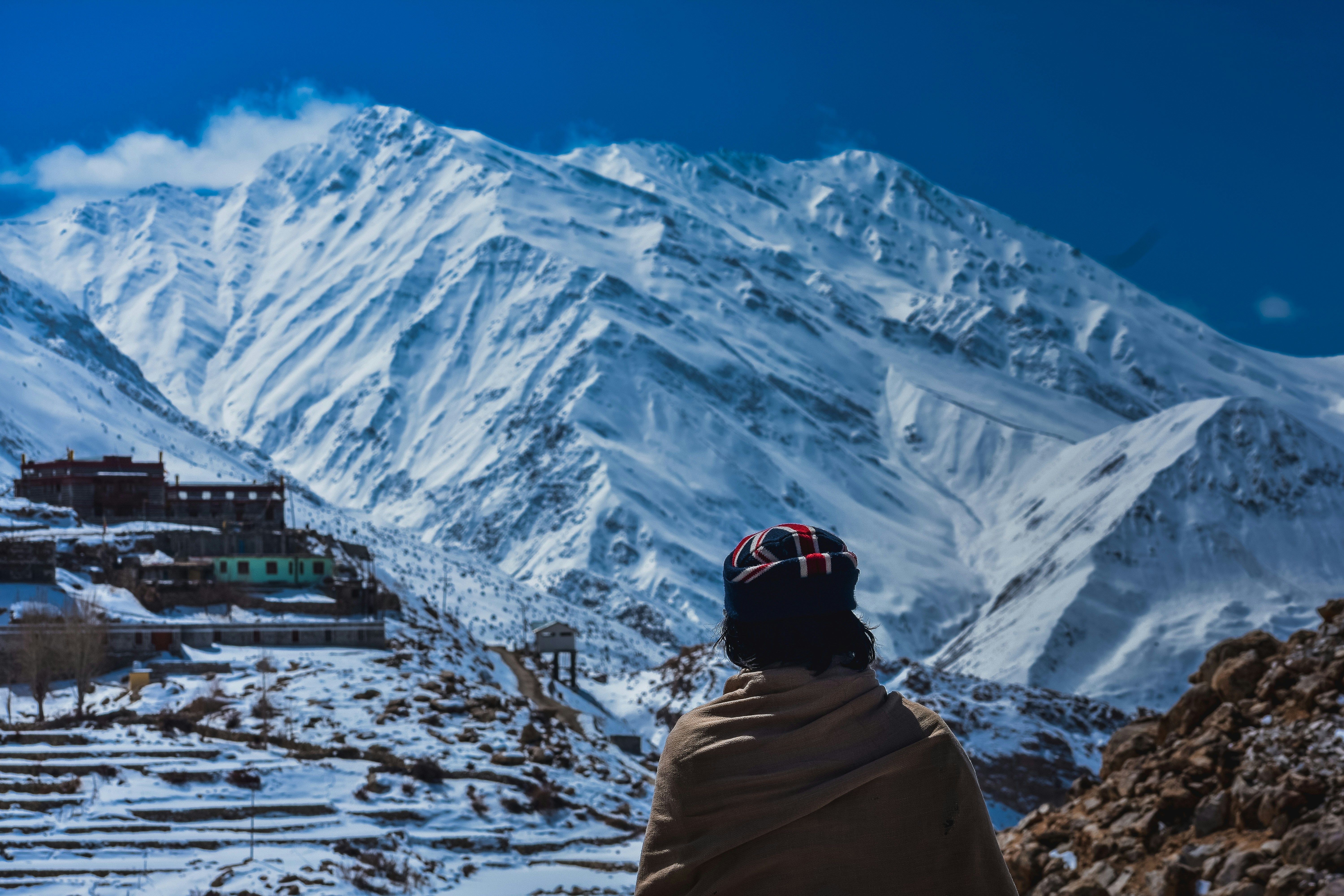 a person in white hoodie standing on snow covered ground during daytime in nako village