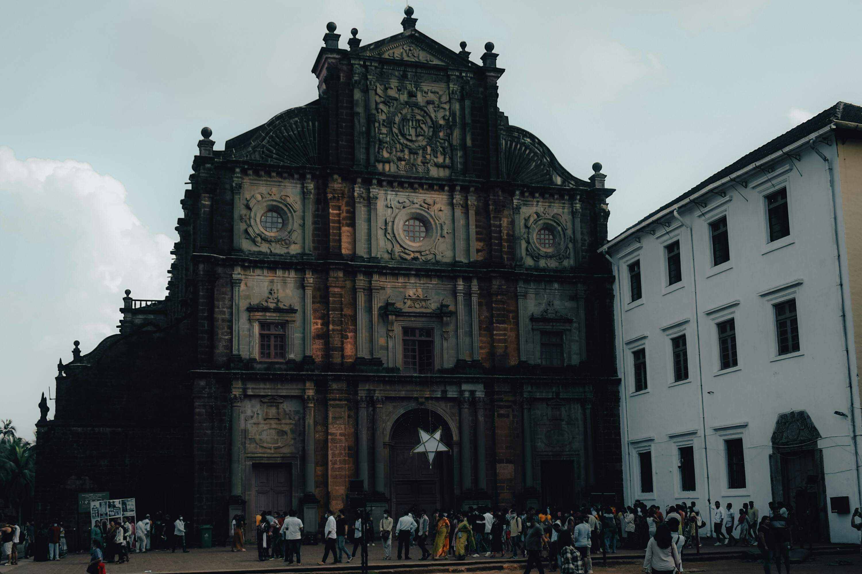 people walking near basilica bom jesus church in goa