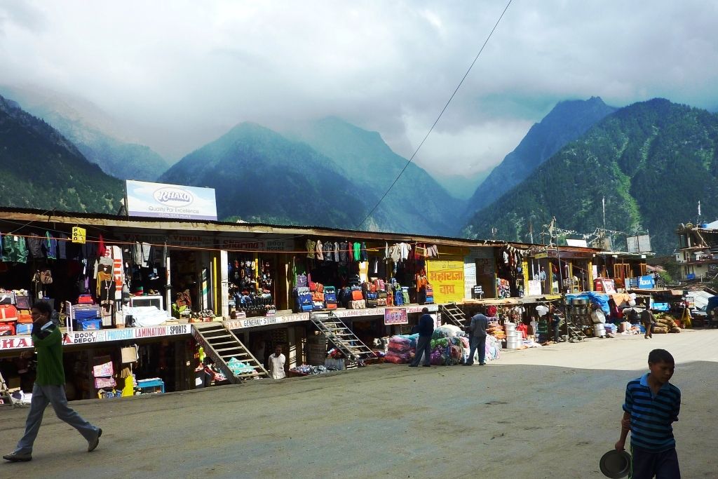 a person walking in front of shops in recong peo market