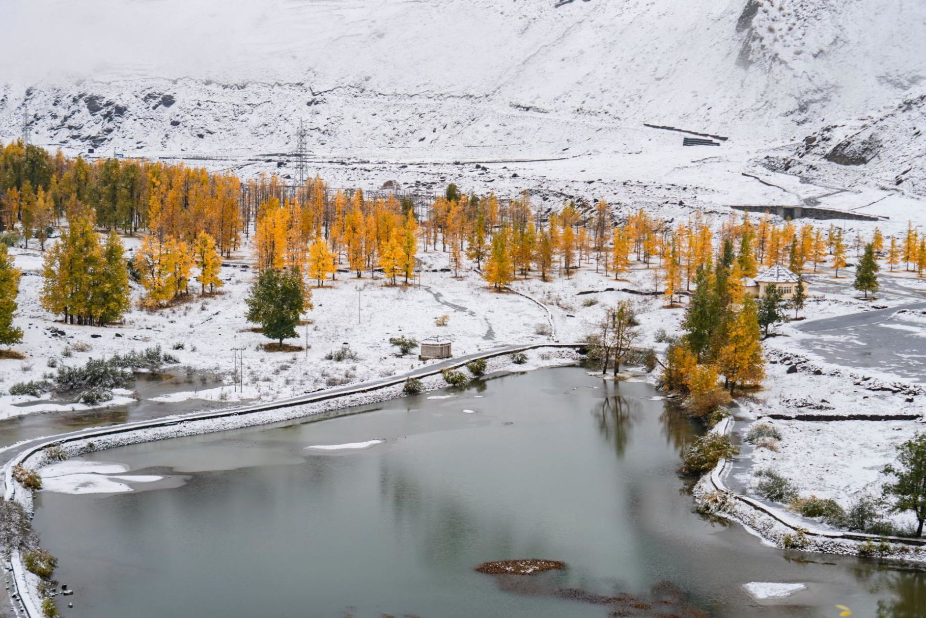 sissu lake surrounded by snow on all sides with snow covered mountains in the backdrop