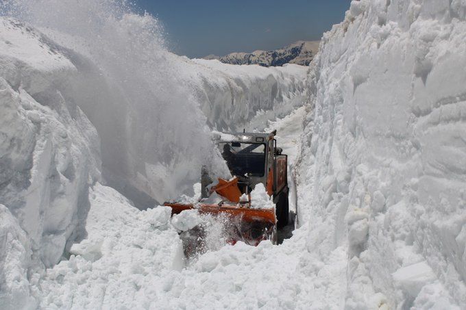 a machine clearing snow at rohtang pass during daytime