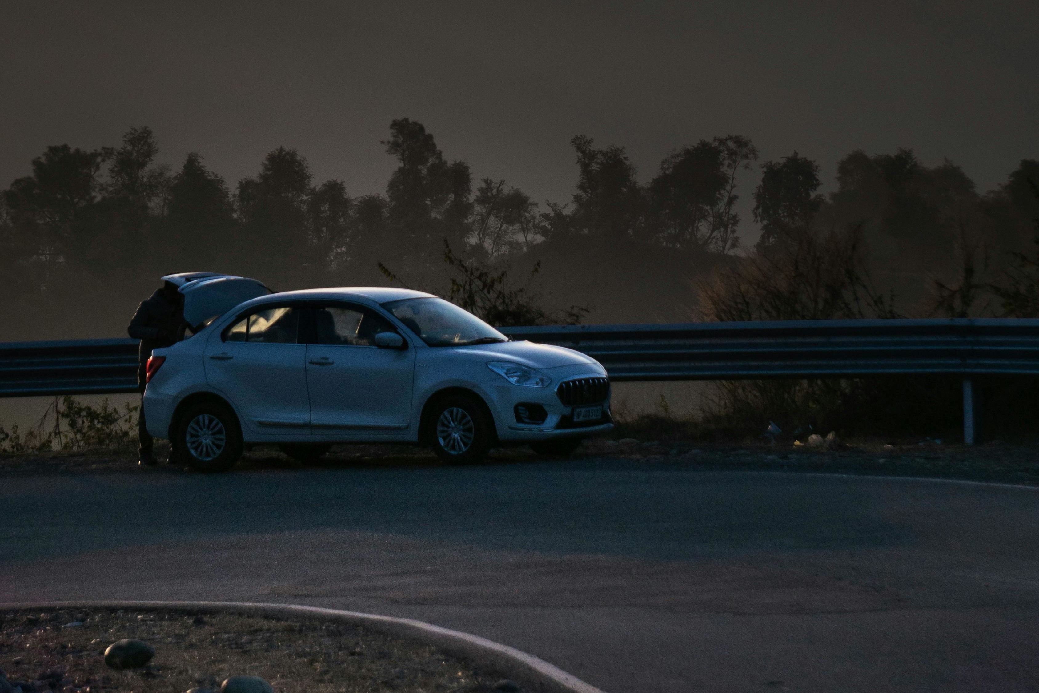 suzuki dzire on a curved road at dusk in dharamshala