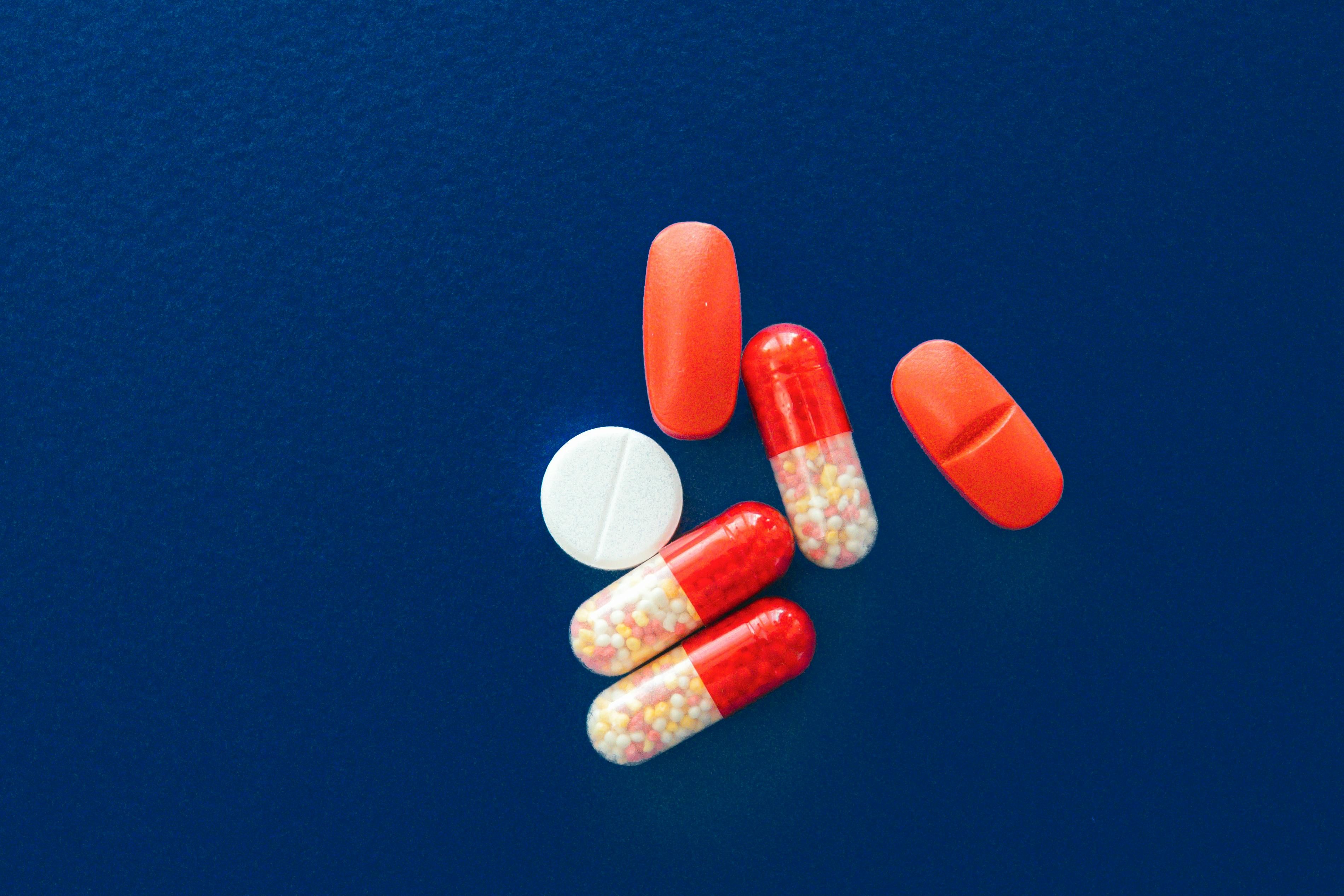 tablets and capsule medicines on a blue surface