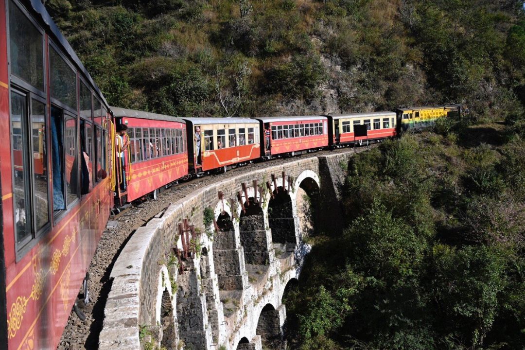 the kalka shimla toy train passing over a bridge