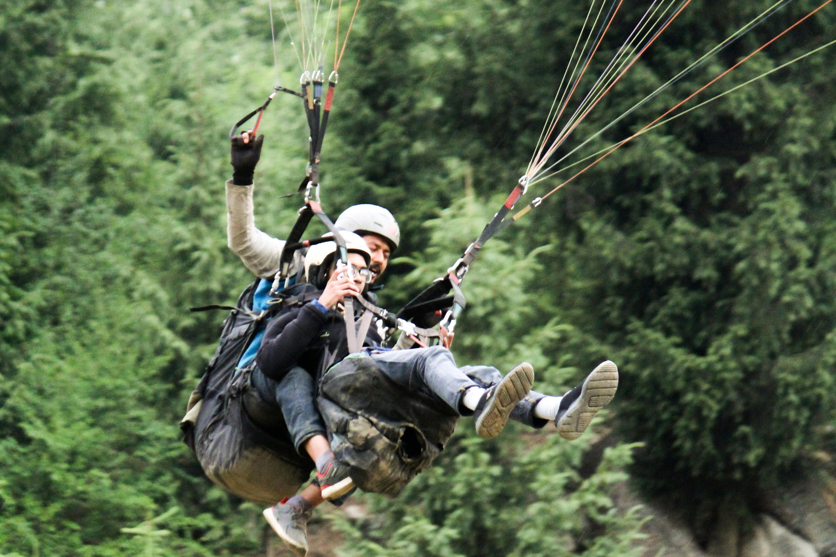 two people enjoying paragliding in solang valley near manali
